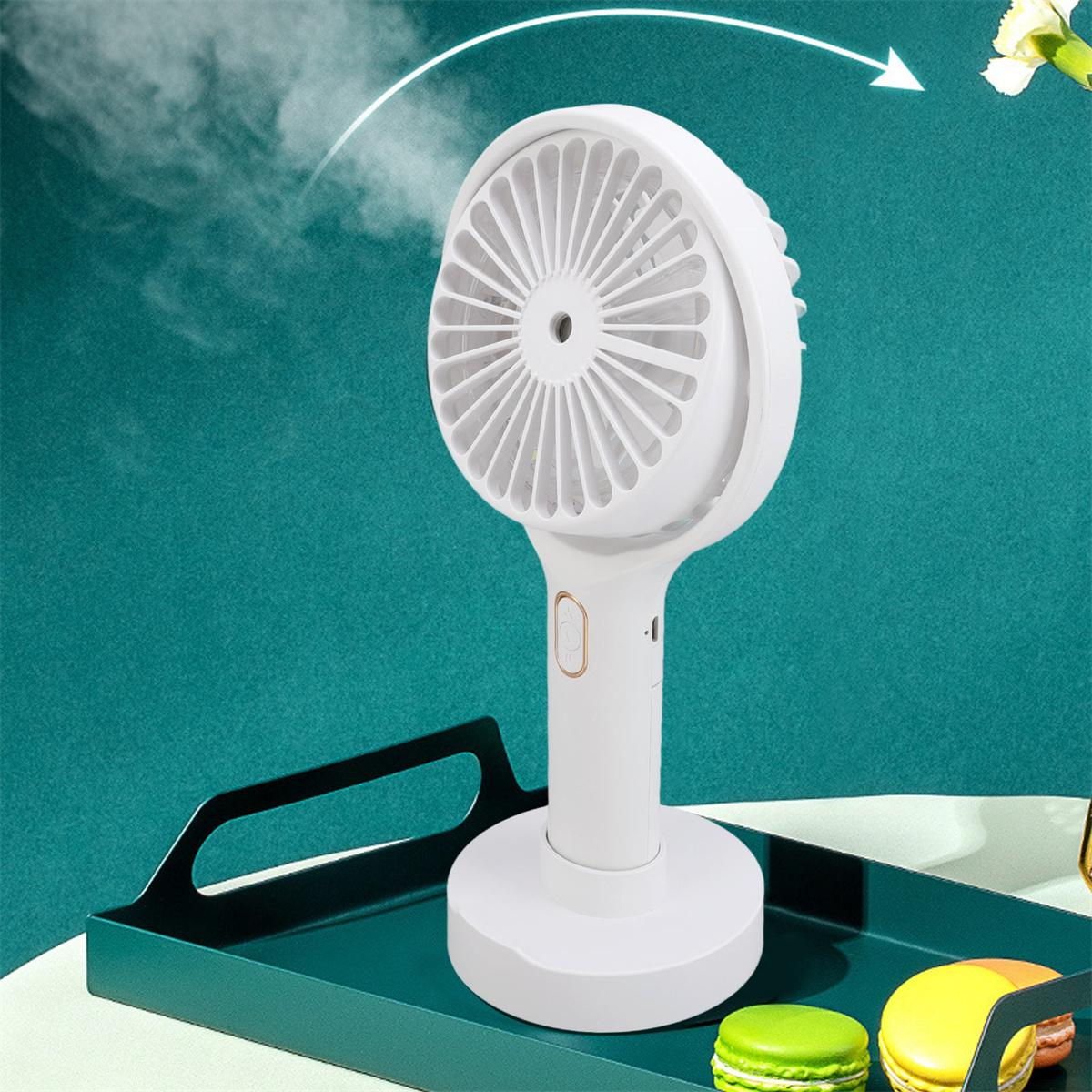 Weißer tragbarer Ventilator mit Griff, auf grünem Tablett mit Makronen.