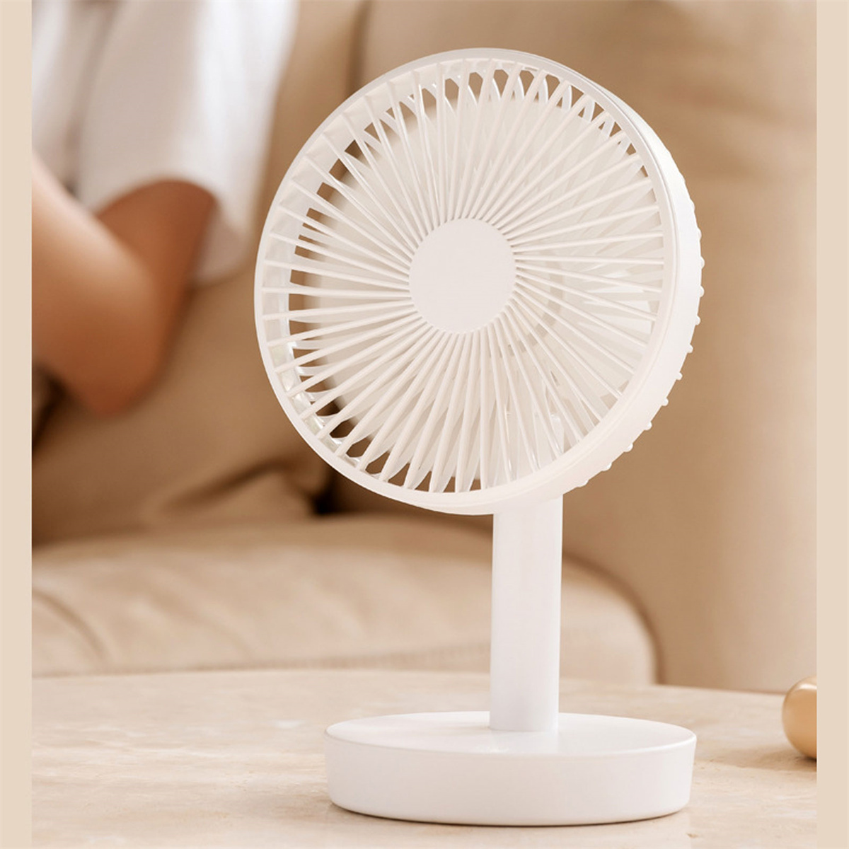 Weißer Schreibtischventilator mit kreisförmigem Design, auf beiger Oberfläche.