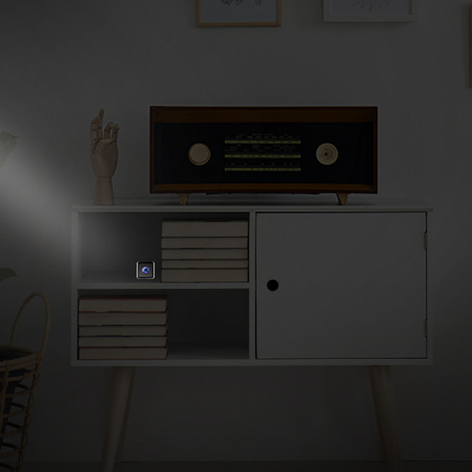 Nachtszenario. Weißer Schrank mit Büchern, einem Radio und einem kleinen beleuchteten Gerät.