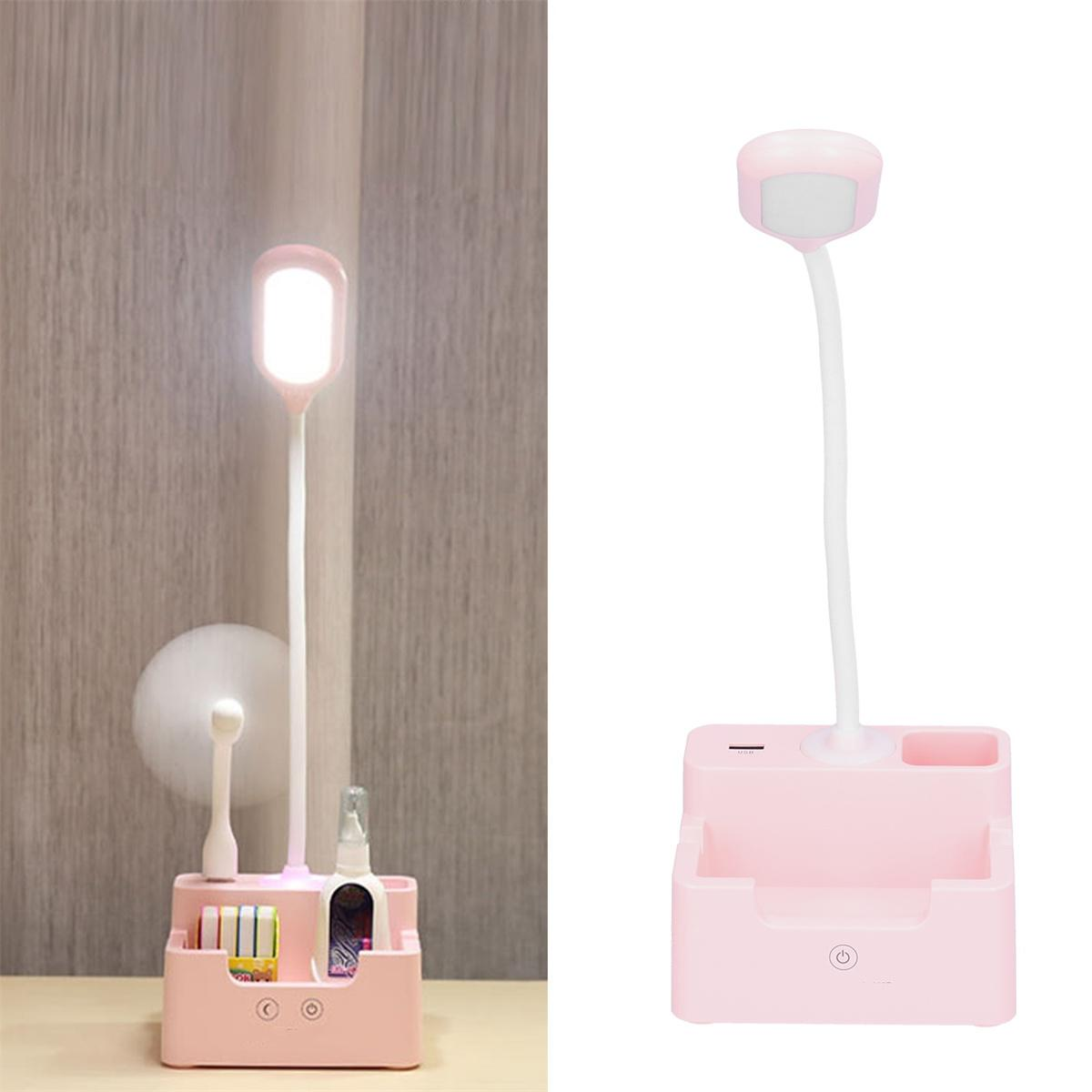 Zwei rosa Schreibtischlampen, eine mit Zahnbürstenhalter und einem Ventilator. Beide haben ein Licht.