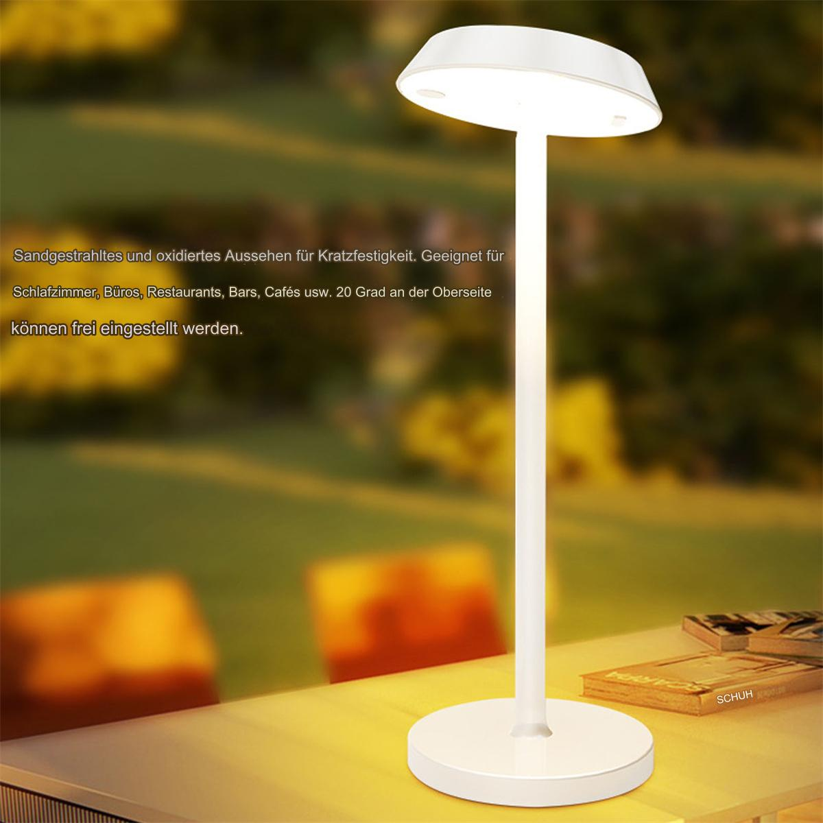 Weiße, moderne Lampe. Die Lampe ist eingeschaltet und wirft Licht auf einen Holztisch mit Buch.