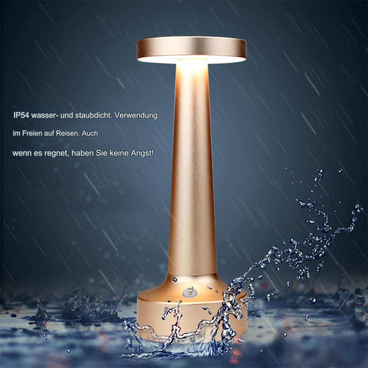 Eine goldene Lampe mit Wasserspritzern vor einem regnerischen Hintergrund.