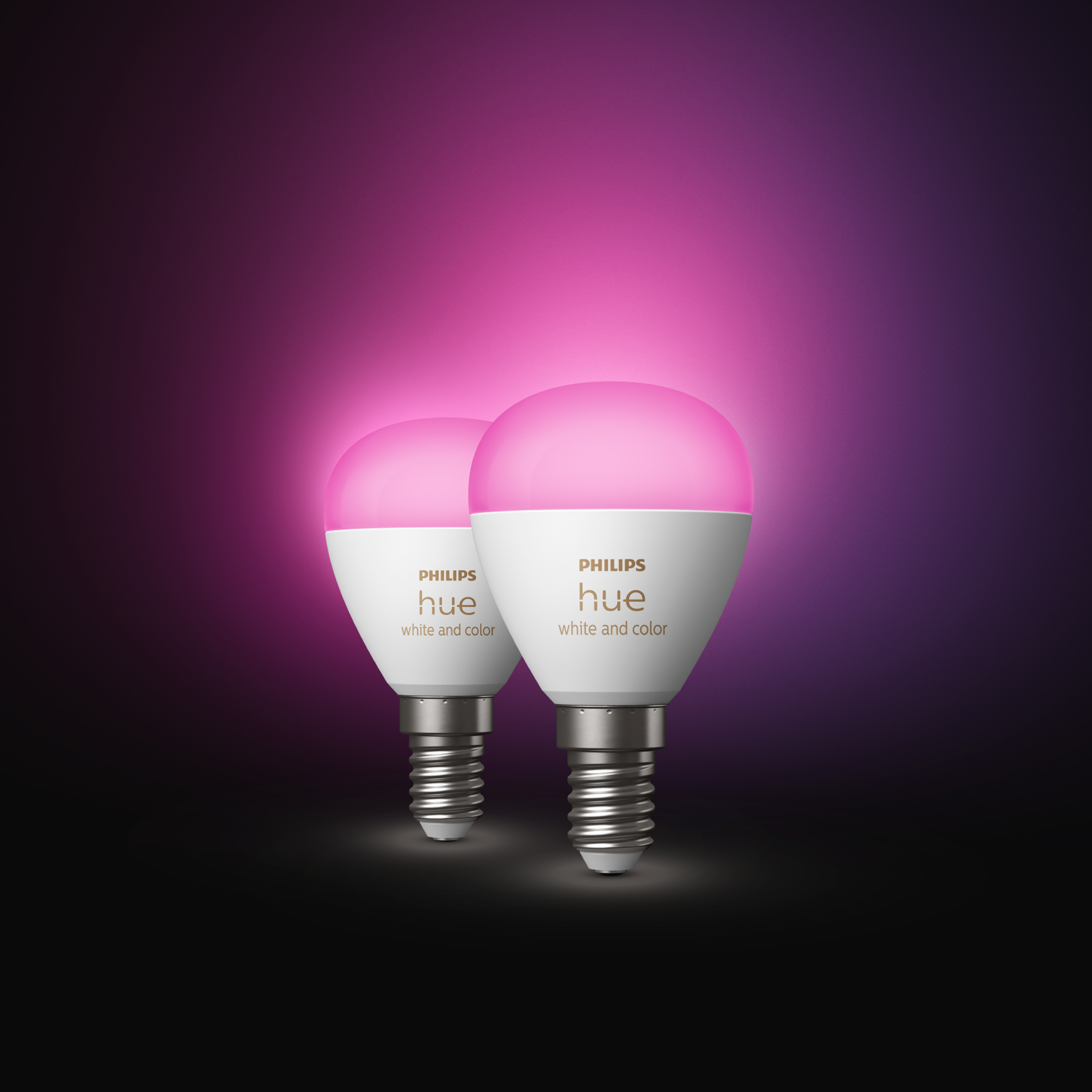 Dwie inteligentne żarówki Philips Hue świecące na różowo, z fioletowym i czarnym tłem.