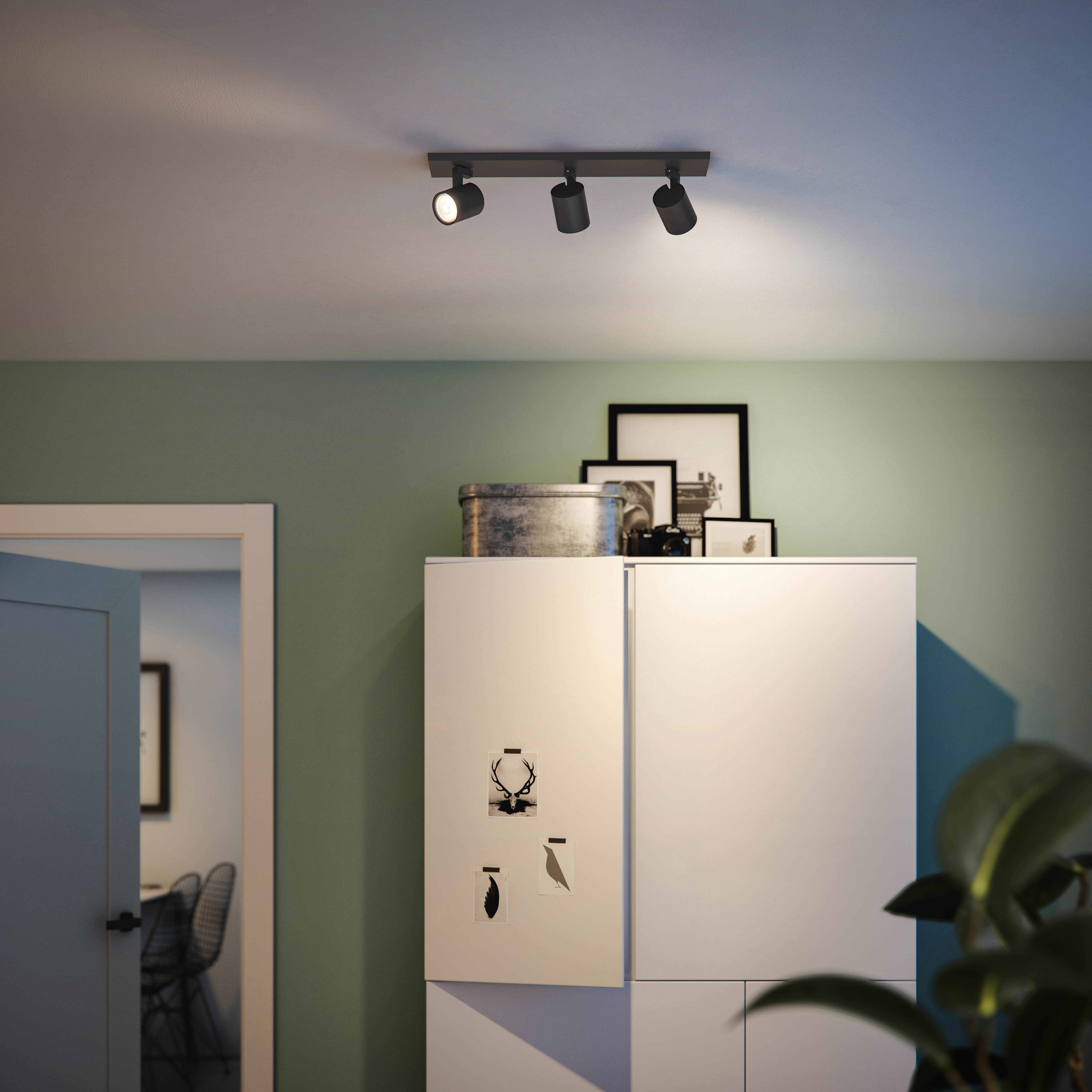 Deckenstrahler beleuchten einen Raum. Weißer Schrank, Dekoration und Türrahmen vorhanden.