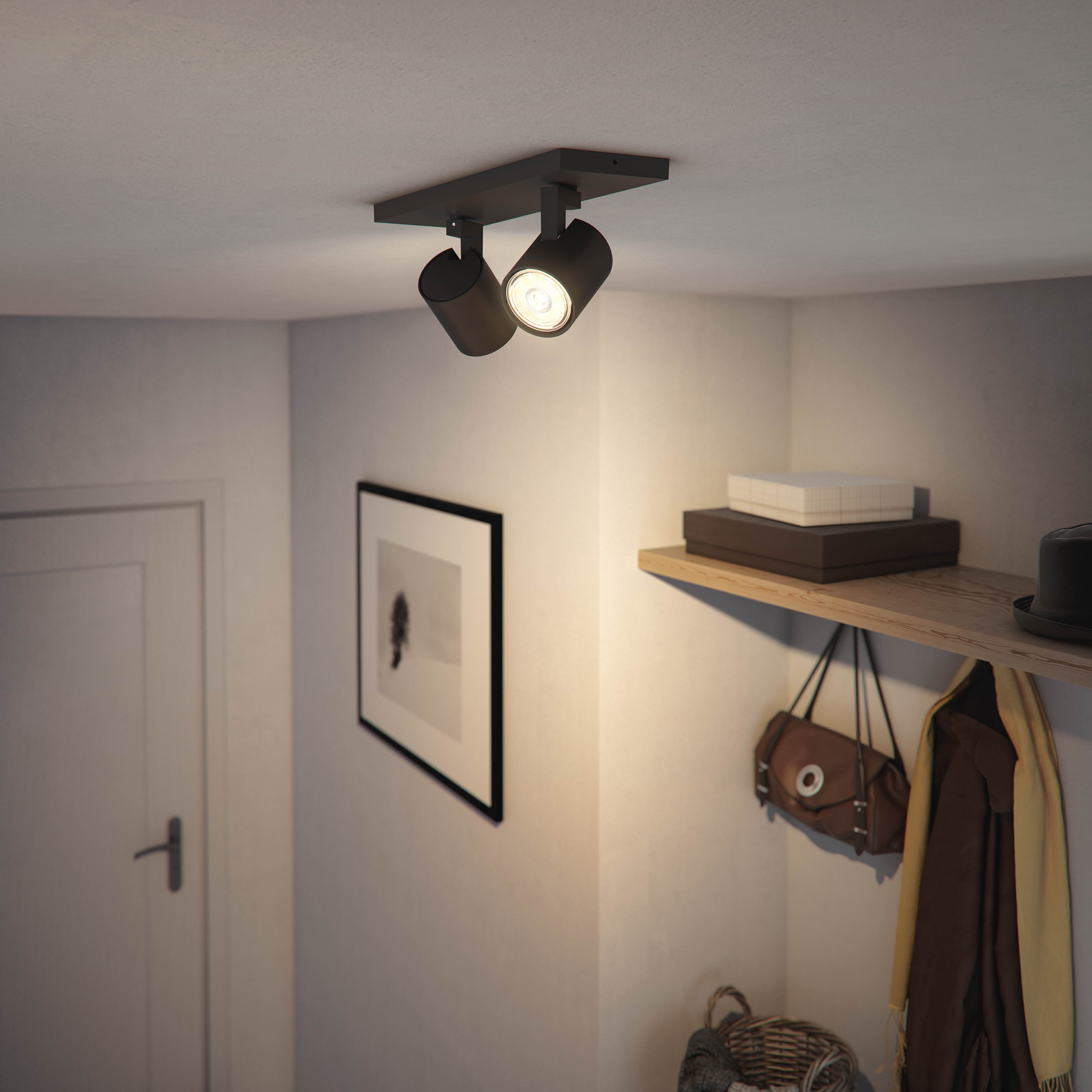 Zwei schwarze Strahler an weißer Decke. Zwei Philips Hue-Glühbirnen unten.