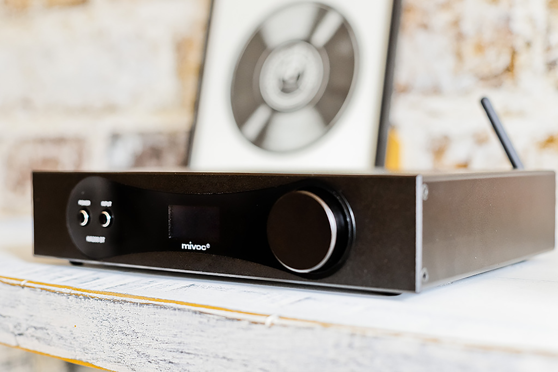 Ein schwarzer Audio-Receiver. Er hat ein Display, Knöpfe und einen Knopf auf der Vorderseite.