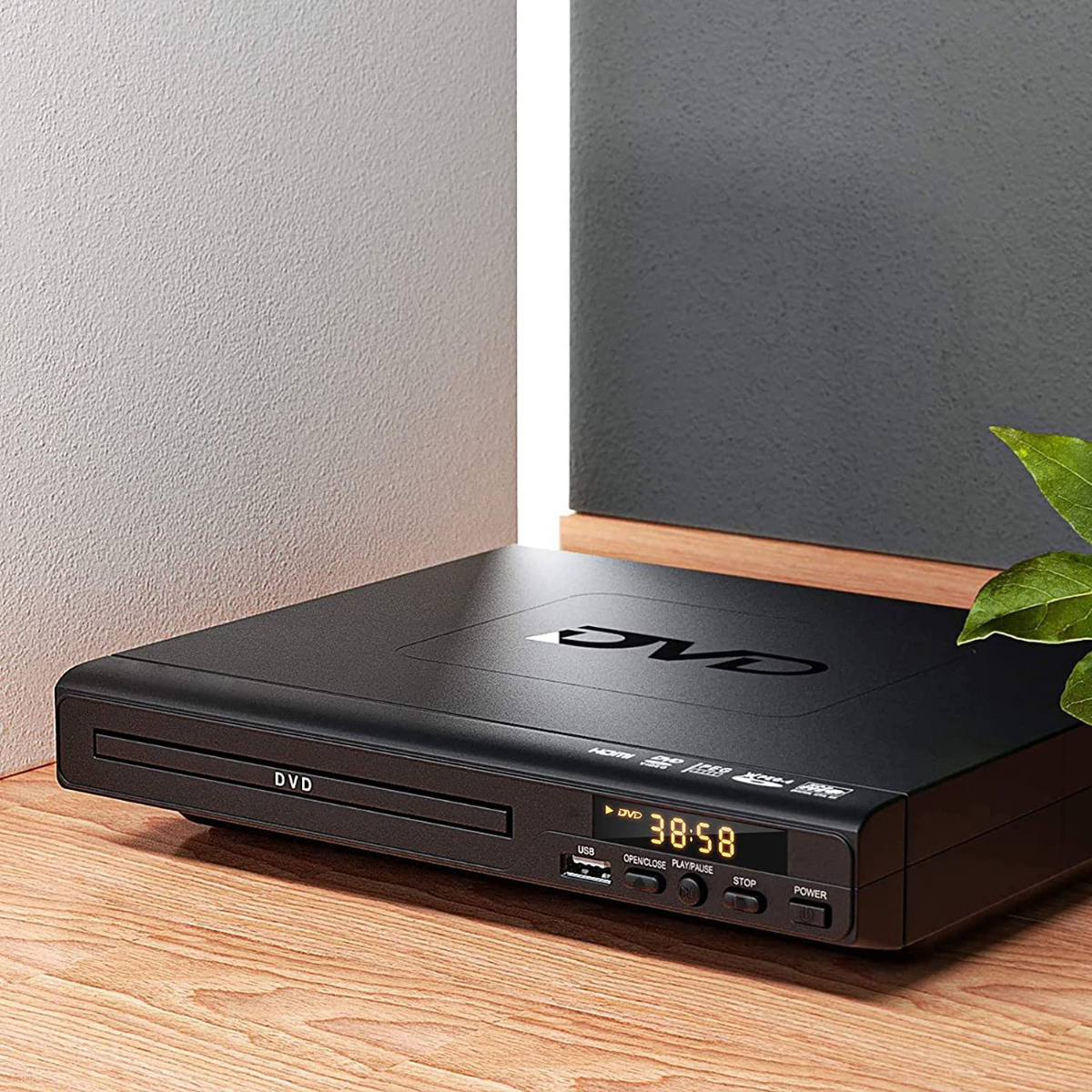 Schwarzer DVD-Player mit Zeitanzeige auf Holzoberfläche.