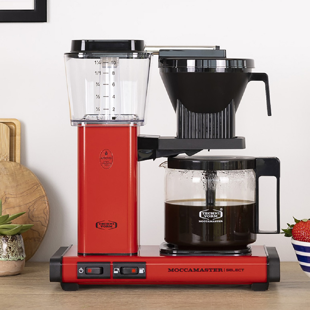 Rood en zwart koffiezetapparaat met een transparante watercontainer en een glazen kan met koffie.