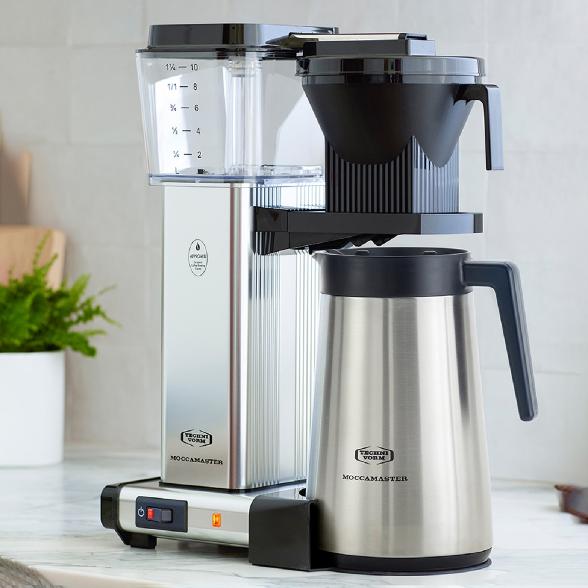 Kaffeemaschine mit Thermokanne auf einer Theke.