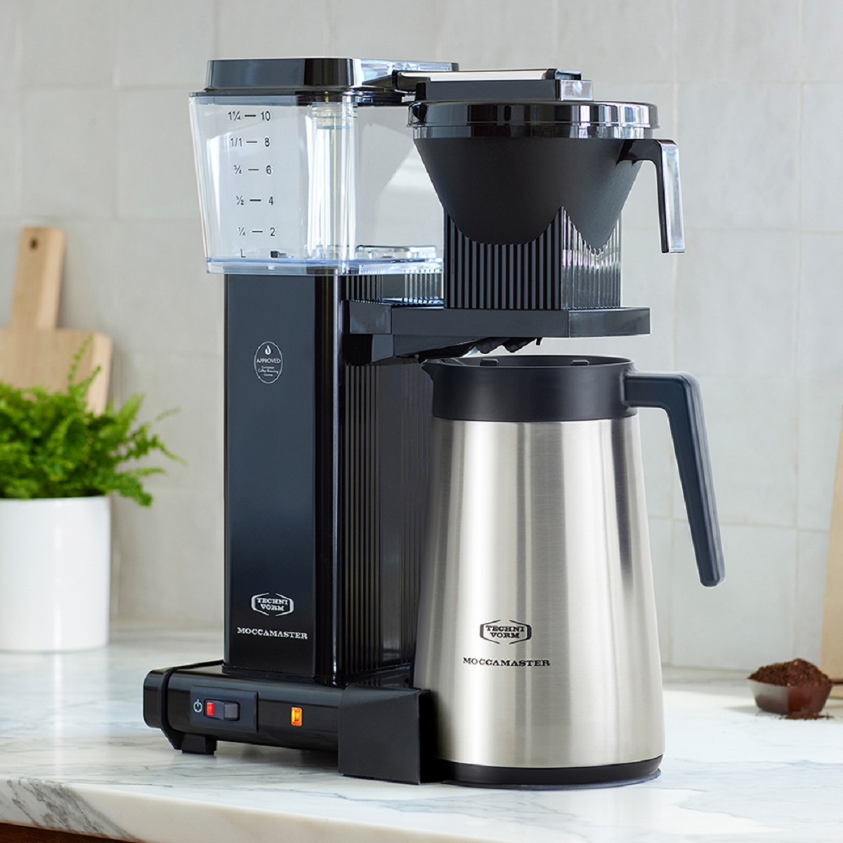 Kaffeemaschine mit schwarzem Gehäuse, Edelstahlkanne und transparentem Wasserbehälter.