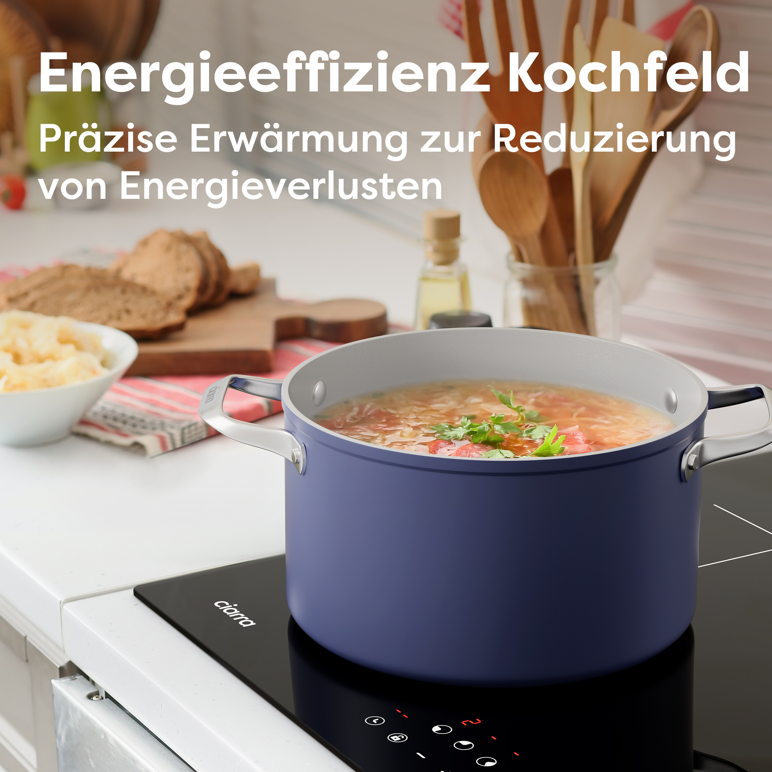 Ein blauer Topf mit Suppe auf einem schwarzen Kochfeld. Geschnittenes Brot und Holzlöffel sind im Hintergrund.