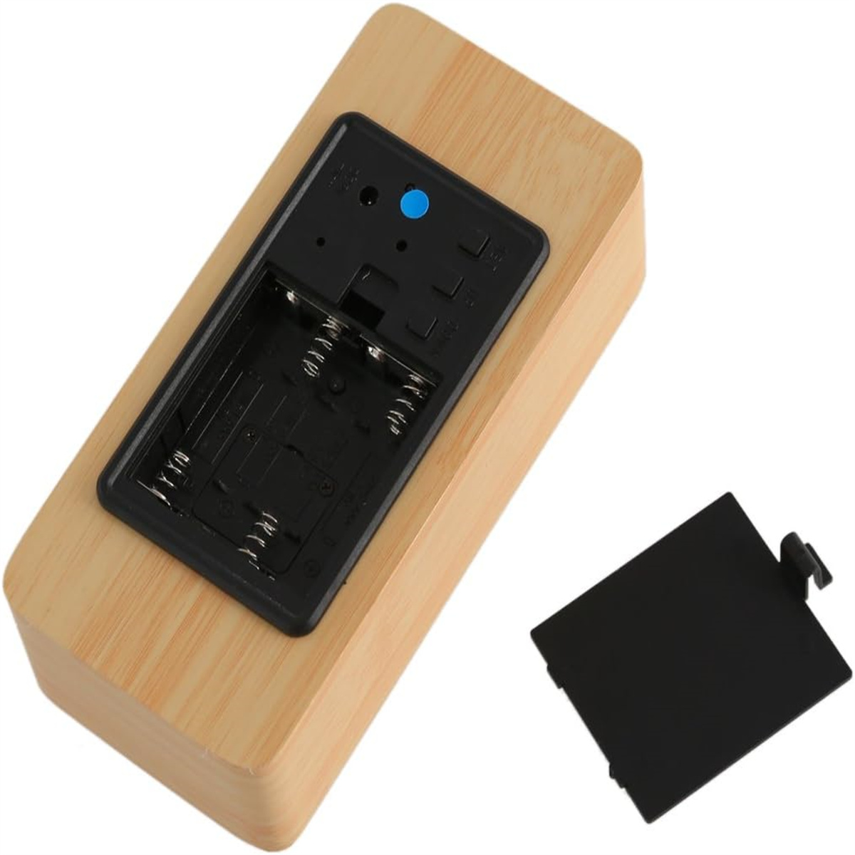 Ein hölzerner Wecker mit offenem Batteriefach und abgenommener Abdeckung.