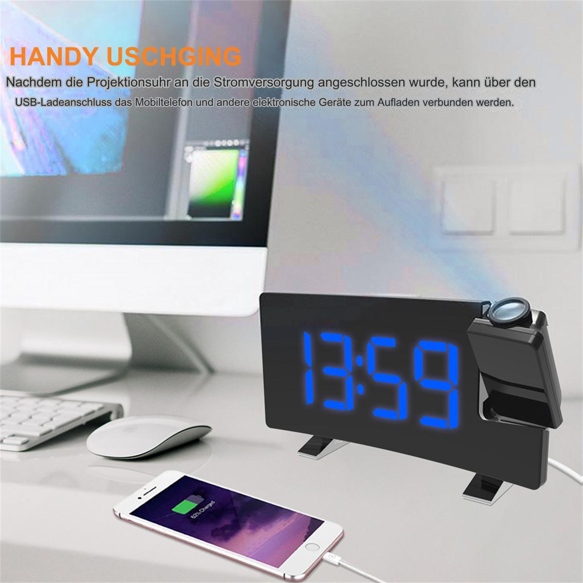 Eine schwarze Digitaluhr mit blauer Anzeige und ein ladendes Telefon. Ein Projektor befindet sich rechts.