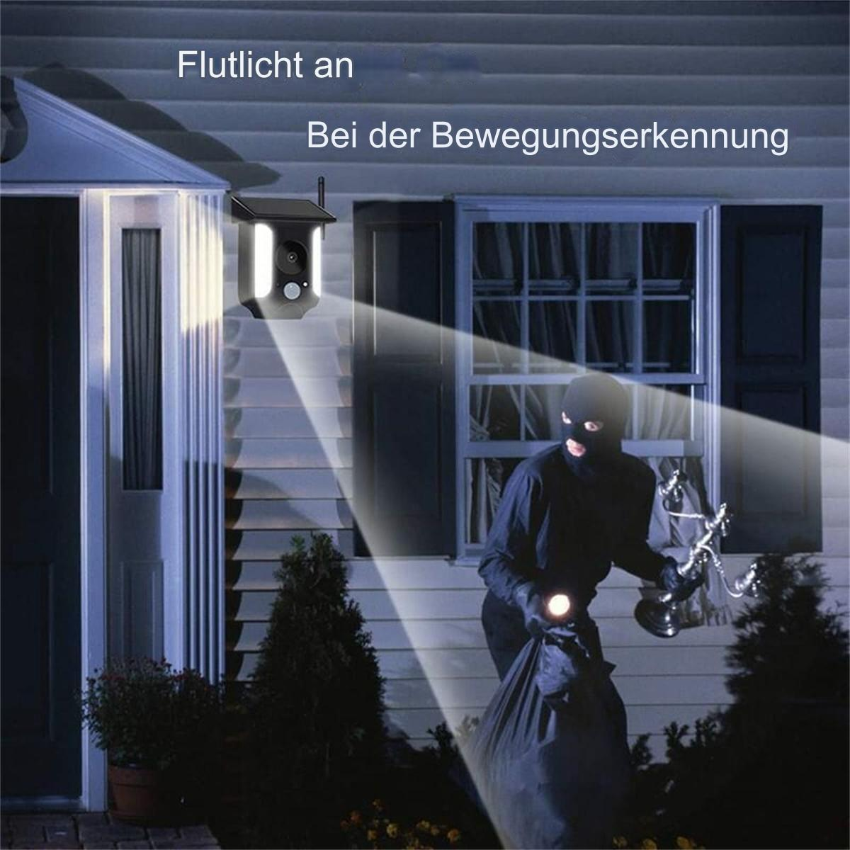 Überwachungskamera mit Scheinwerfer, der auf einen Einbrecher leuchtet. Haus im Hintergrund.