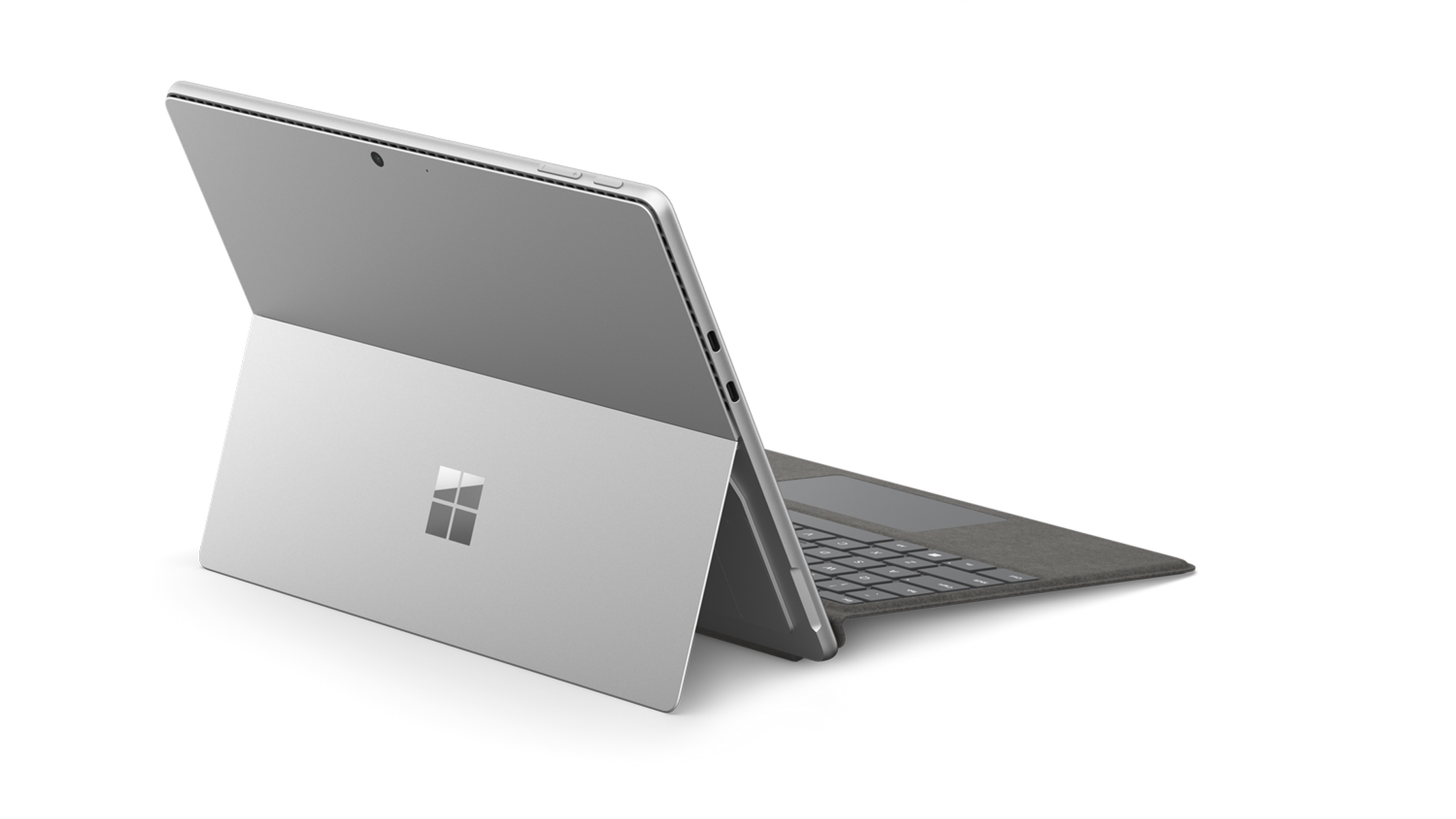 Laptop argentato con logo Microsoft sul retro, aperto ad angolo su sfondo nero.