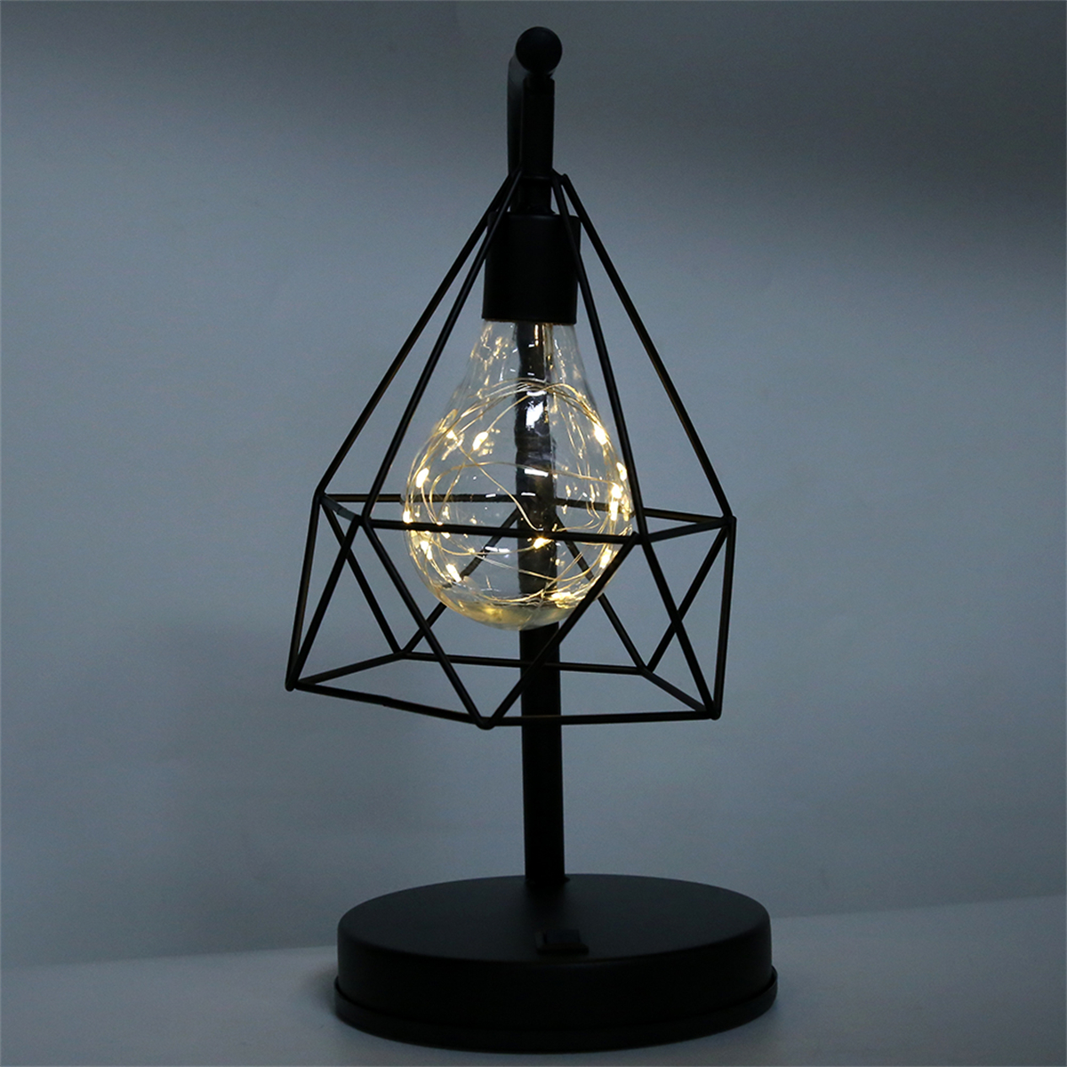 Schwarze Tischlampe mit geometrischem Design und einer Glühbirne mit kleinen Lichtern im Inneren.