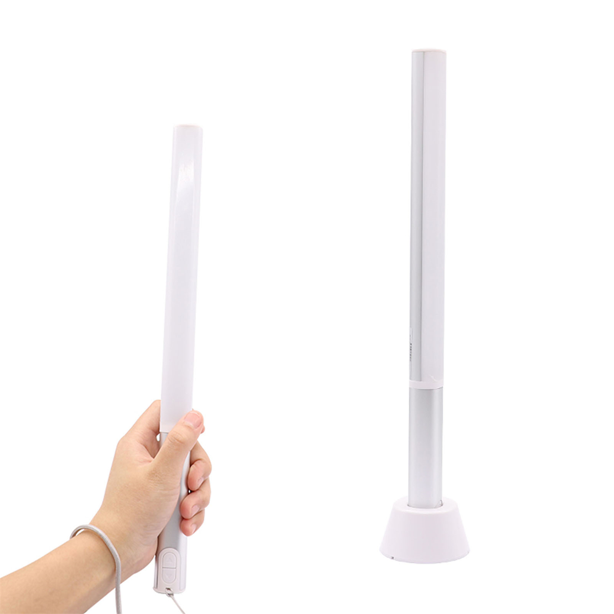 Zwei weiße LED-Leuchten, eine in der Hand, die andere auf einem weißen Sockel, vor weißem Hintergrund.