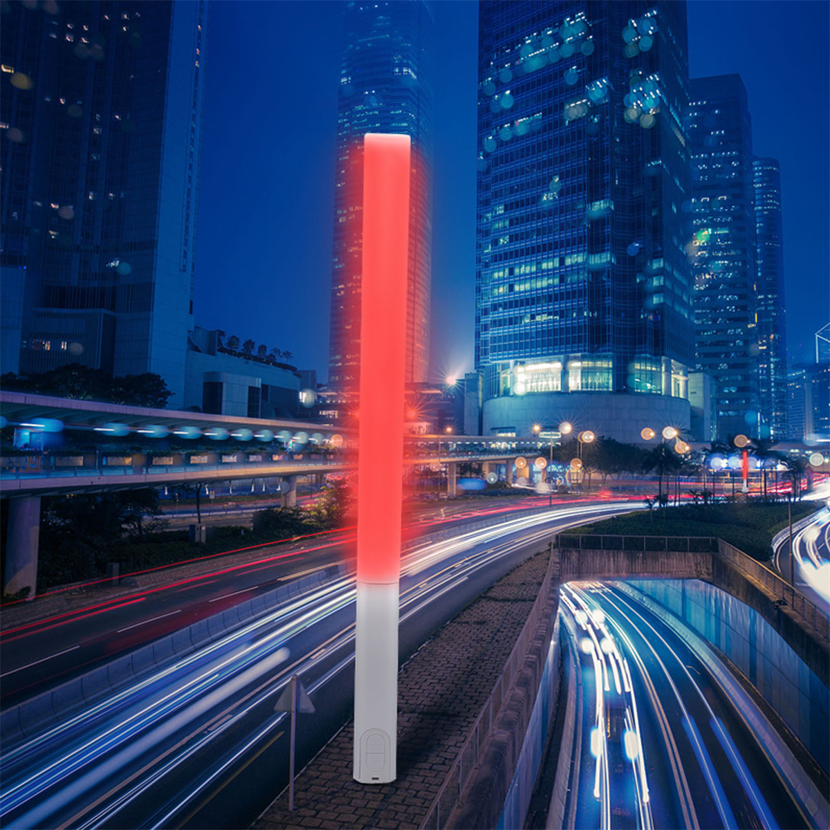 Ein roter Lichtstrahl in einer Stadt bei Nacht. Gebäude und Autobahnlichter im Hintergrund.