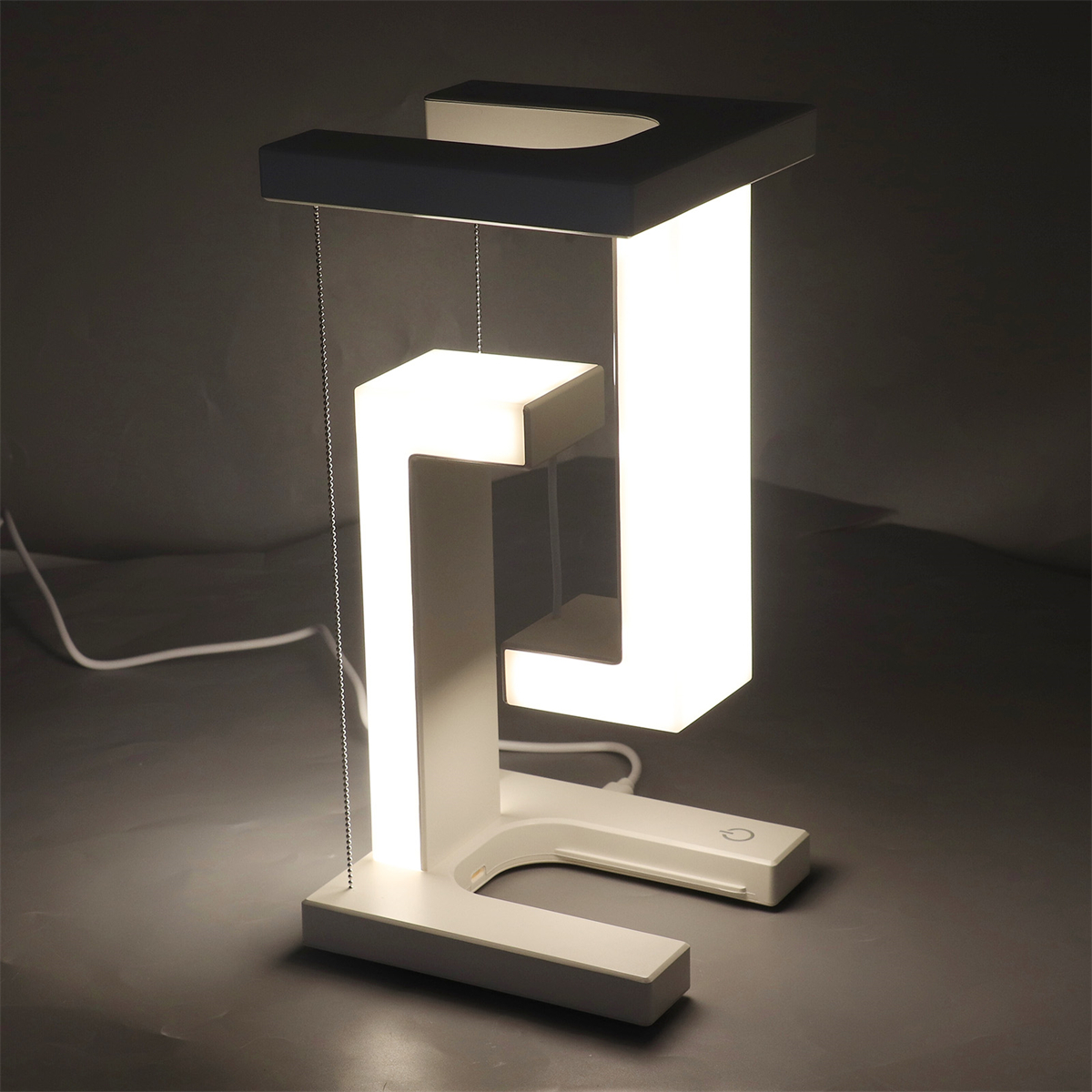 Eine weiße LED-Tischlampe mit einzigartigem Design. Die Lampe leuchtet und zeigt ihre Struktur.