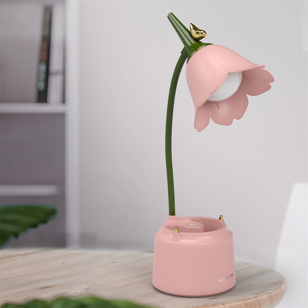 Rosa blütenförmige Schreibtischlampe mit grünem Stiel und goldenem Akzent.