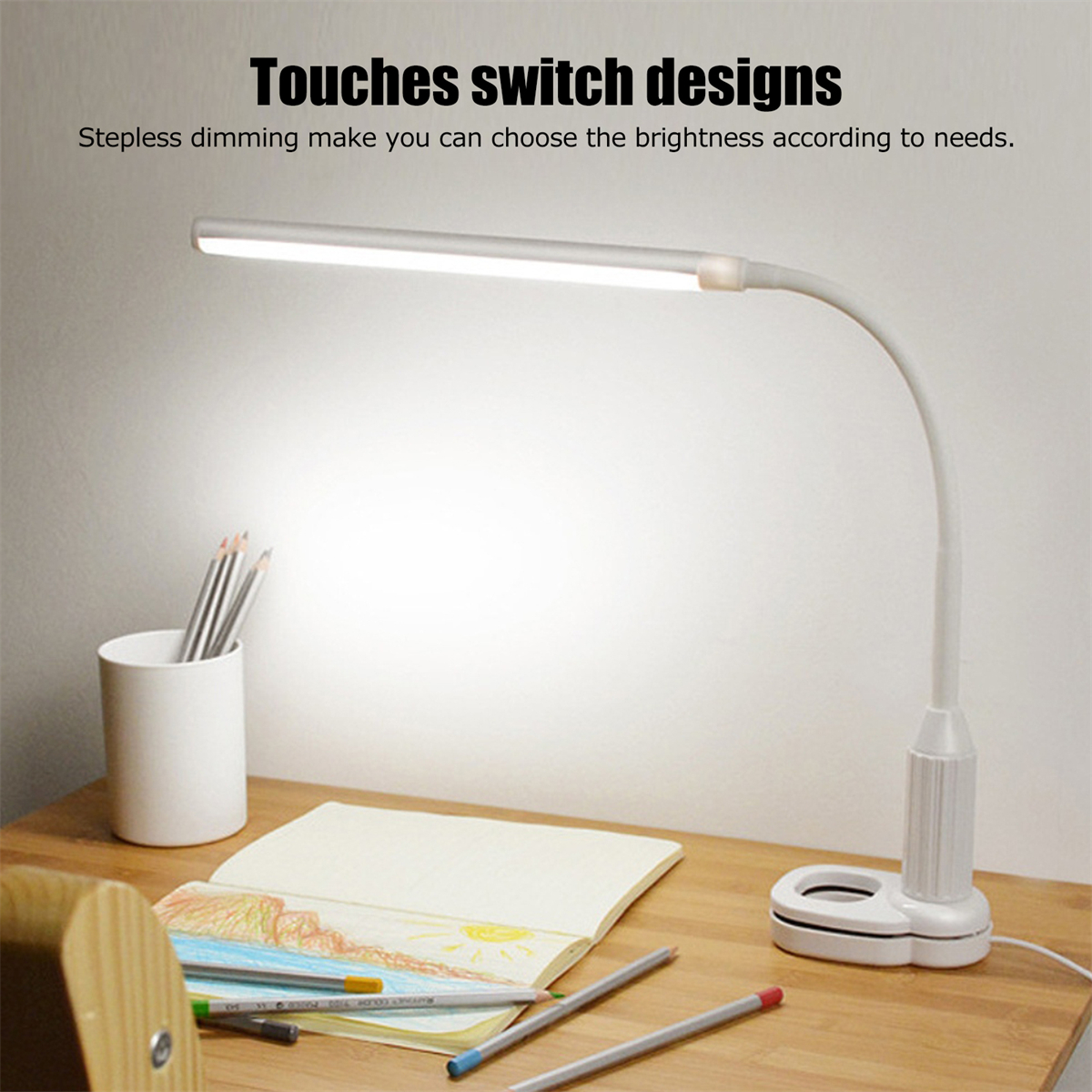 Weiße Schreibtischlampe mit biegsamem Hals und Bleistiften, Notizbuch auf dem Schreibtisch.
