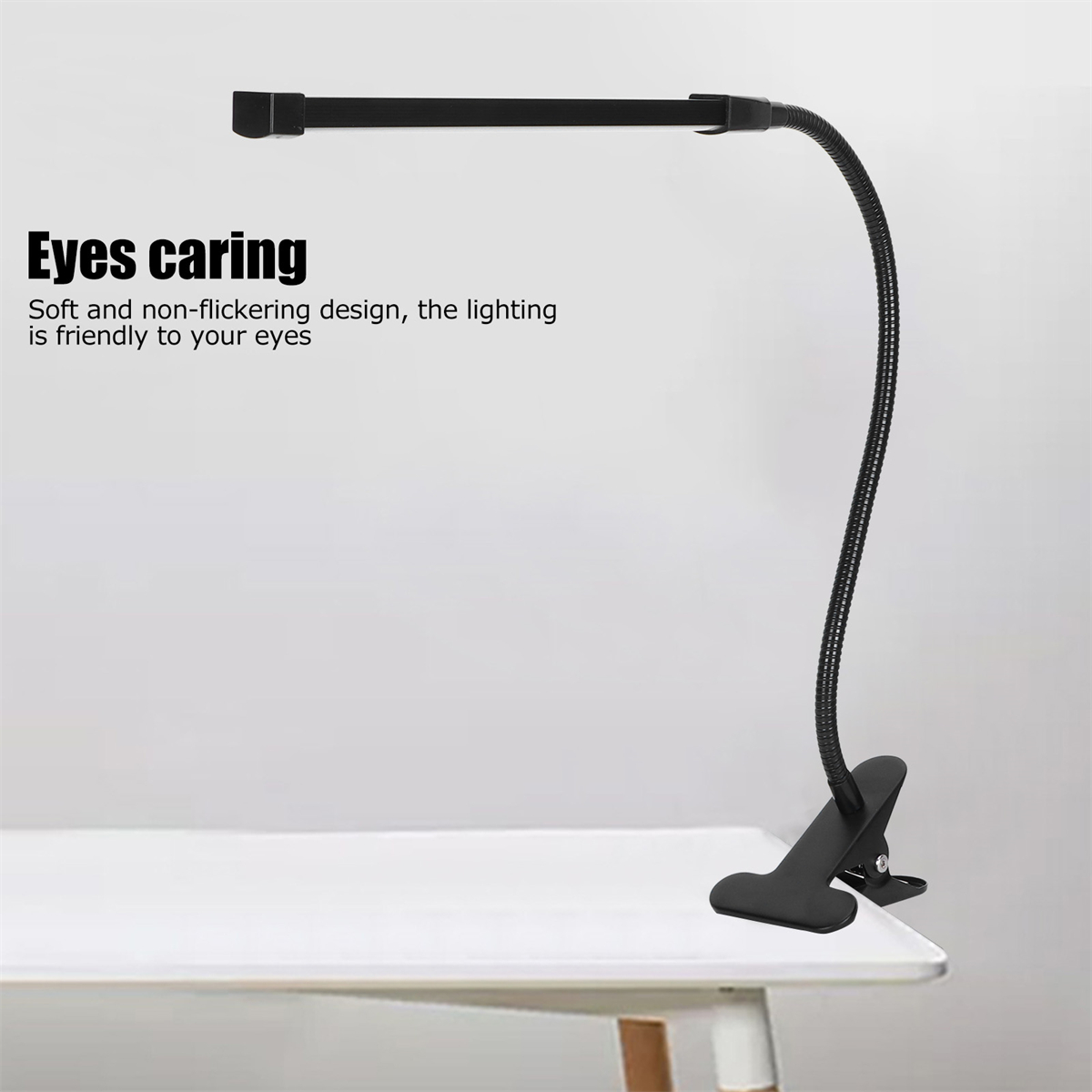Eine schwarze Schreibtischlampe mit flexiblem Hals steht auf einem weißen Schreibtisch.
