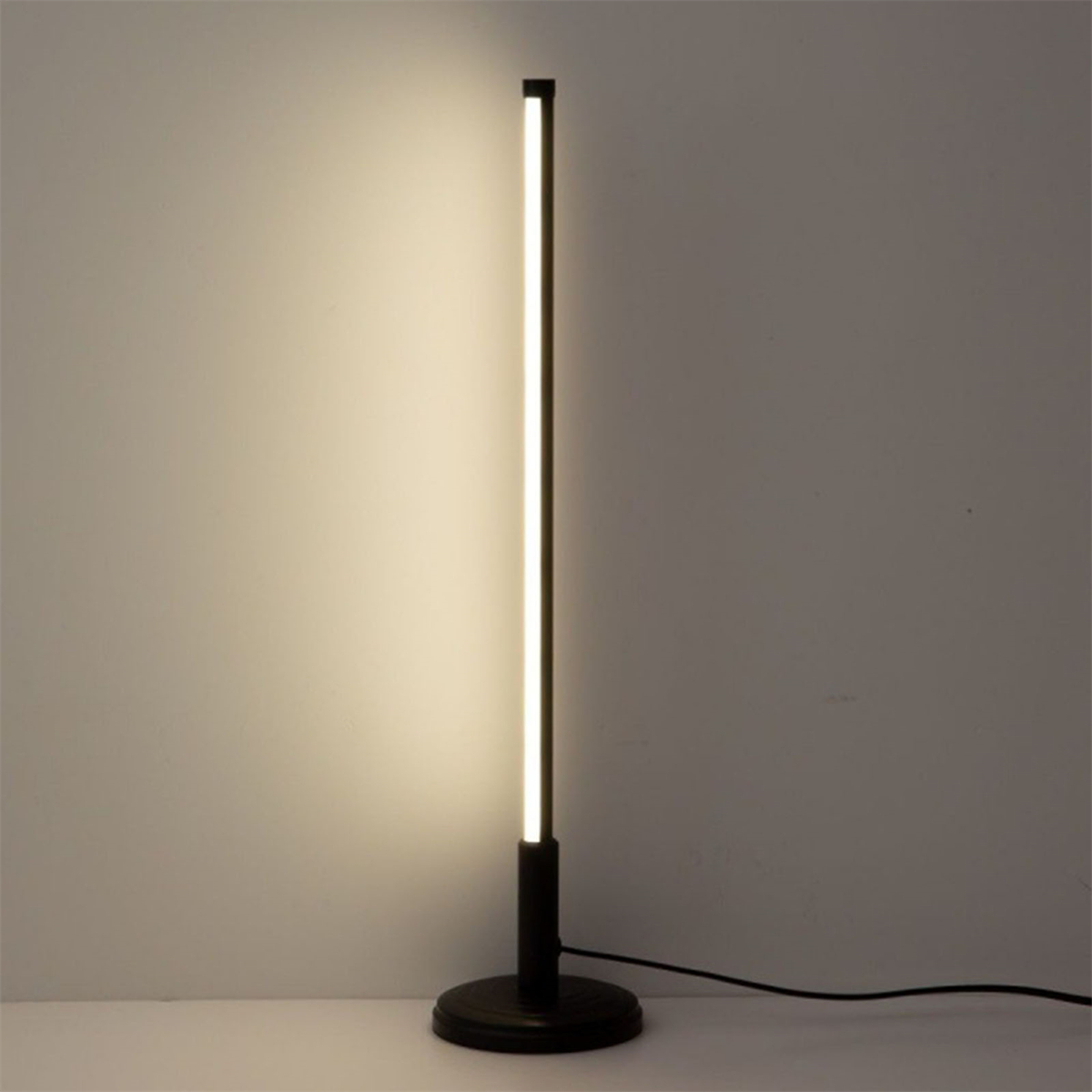 Eine hohe, schwarze Stehlampe mit einem einzelnen, vertikalen Lichtstreifen.