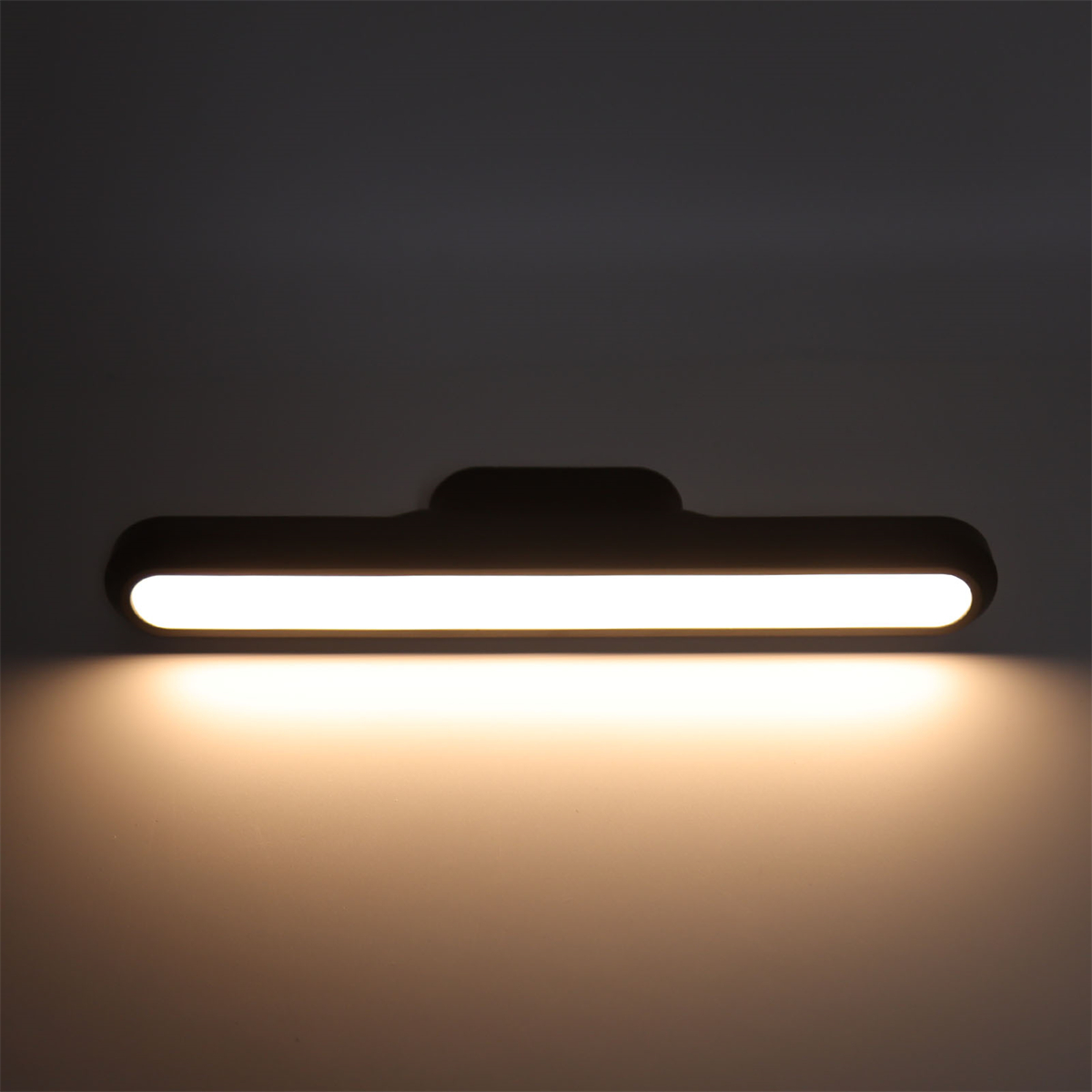 Eine lange, schwarze LED-Leuchte ist an einer Wand montiert. Das Licht ist an.