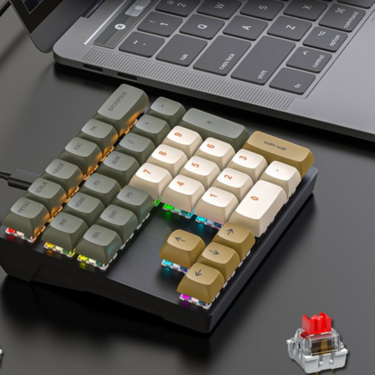 Nahaufnahme eines numerischen Keypads, mit verschiedenfarbig beleuchteten Tasten und einer Laptop-Tastatur im Hintergrund.