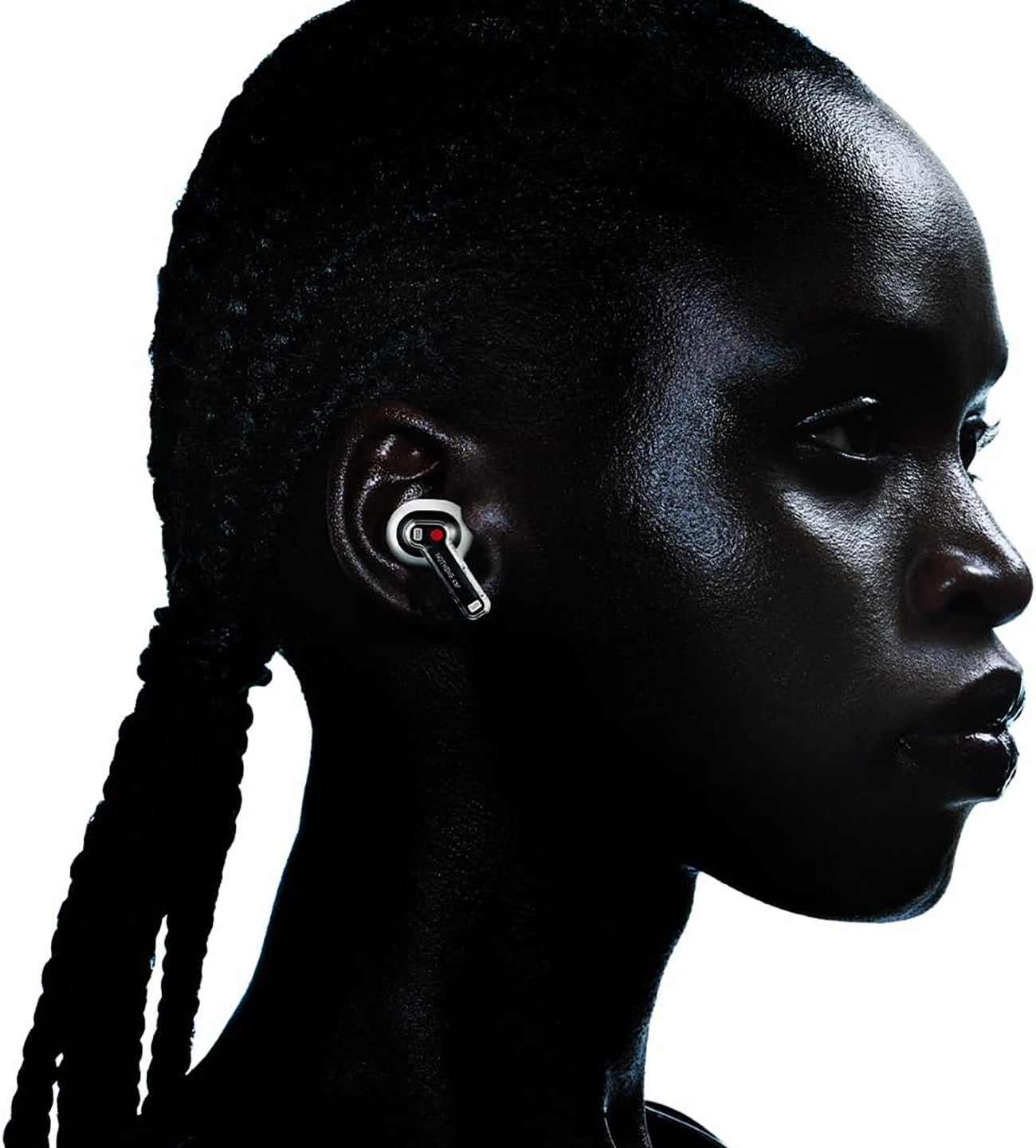 Ujęcie z profilu osoby noszącej czarną słuchawkę, z białym tłem, prezentujące produkt.