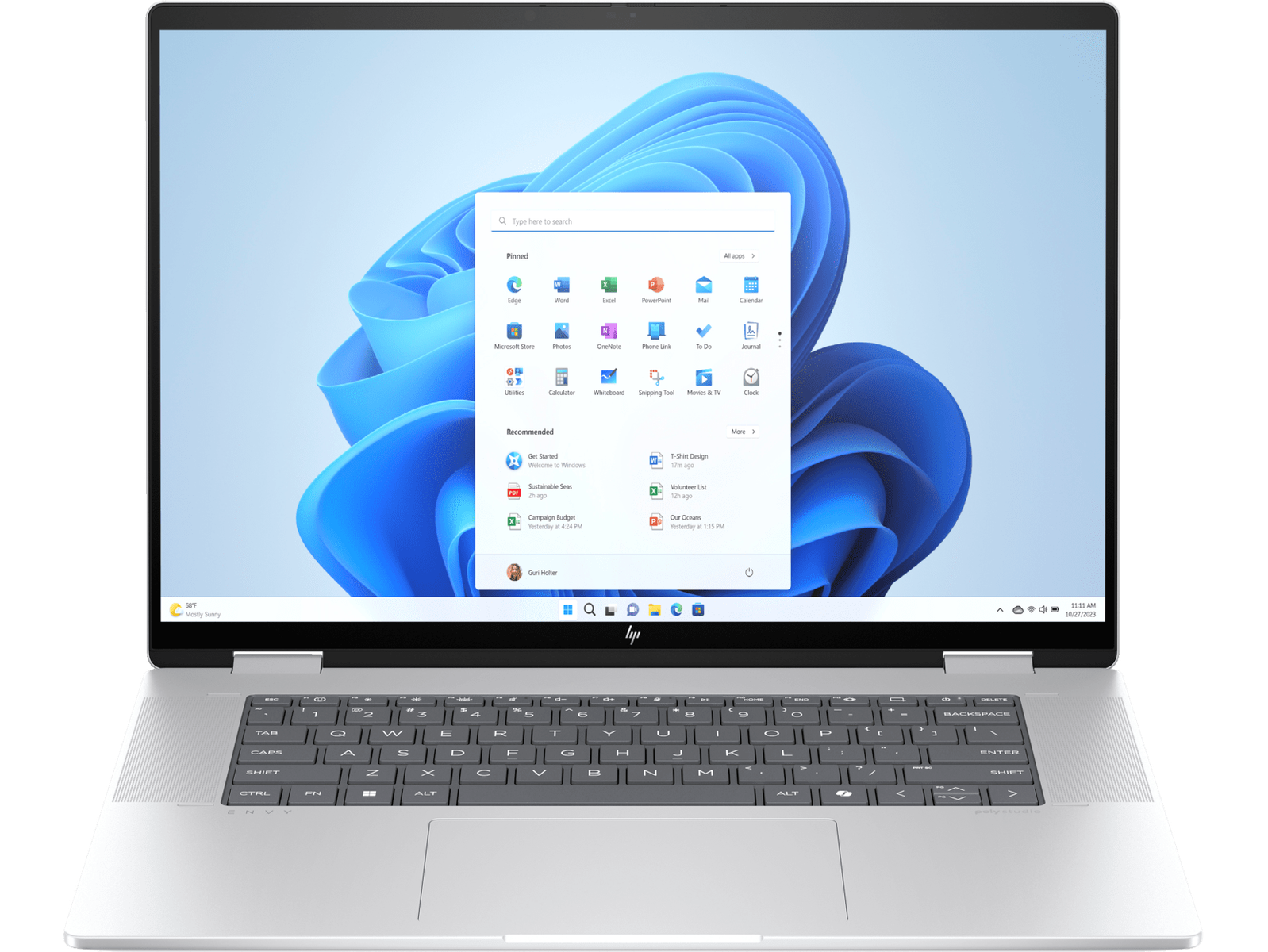 Un portátil con una pantalla de Windows 11 abierta, mostrando aplicaciones. Es plateado y abierto sobre fondo negro.