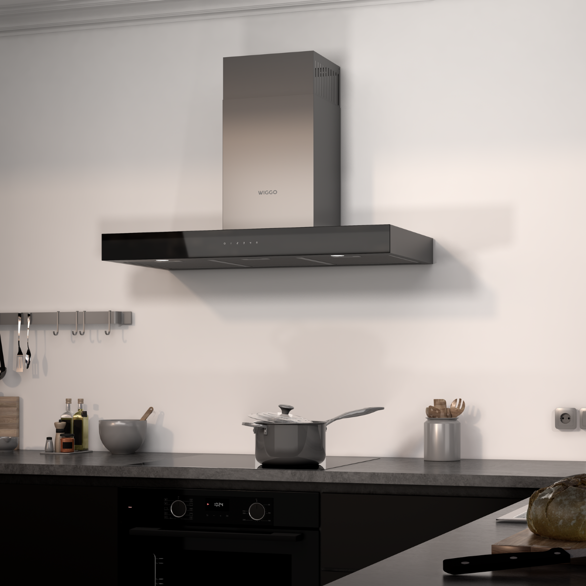 Une hotte noire suspendue au-dessus d'une table de cuisson noire dans une cuisine.