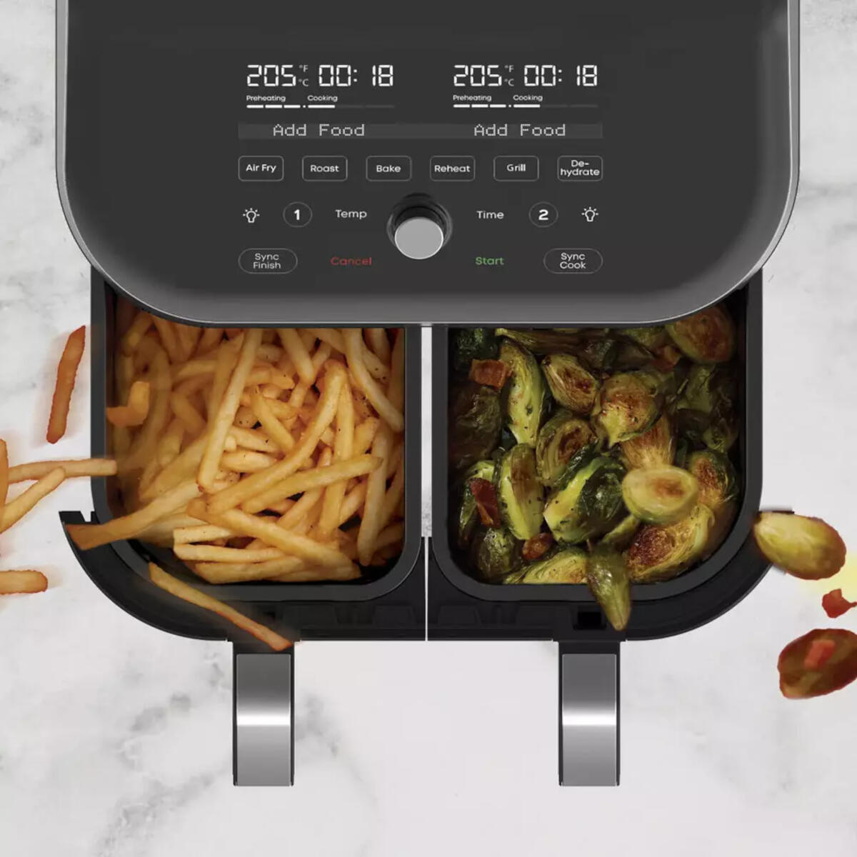 Top-down view of a dual-basket air fryer with french fries and vegetables visible.