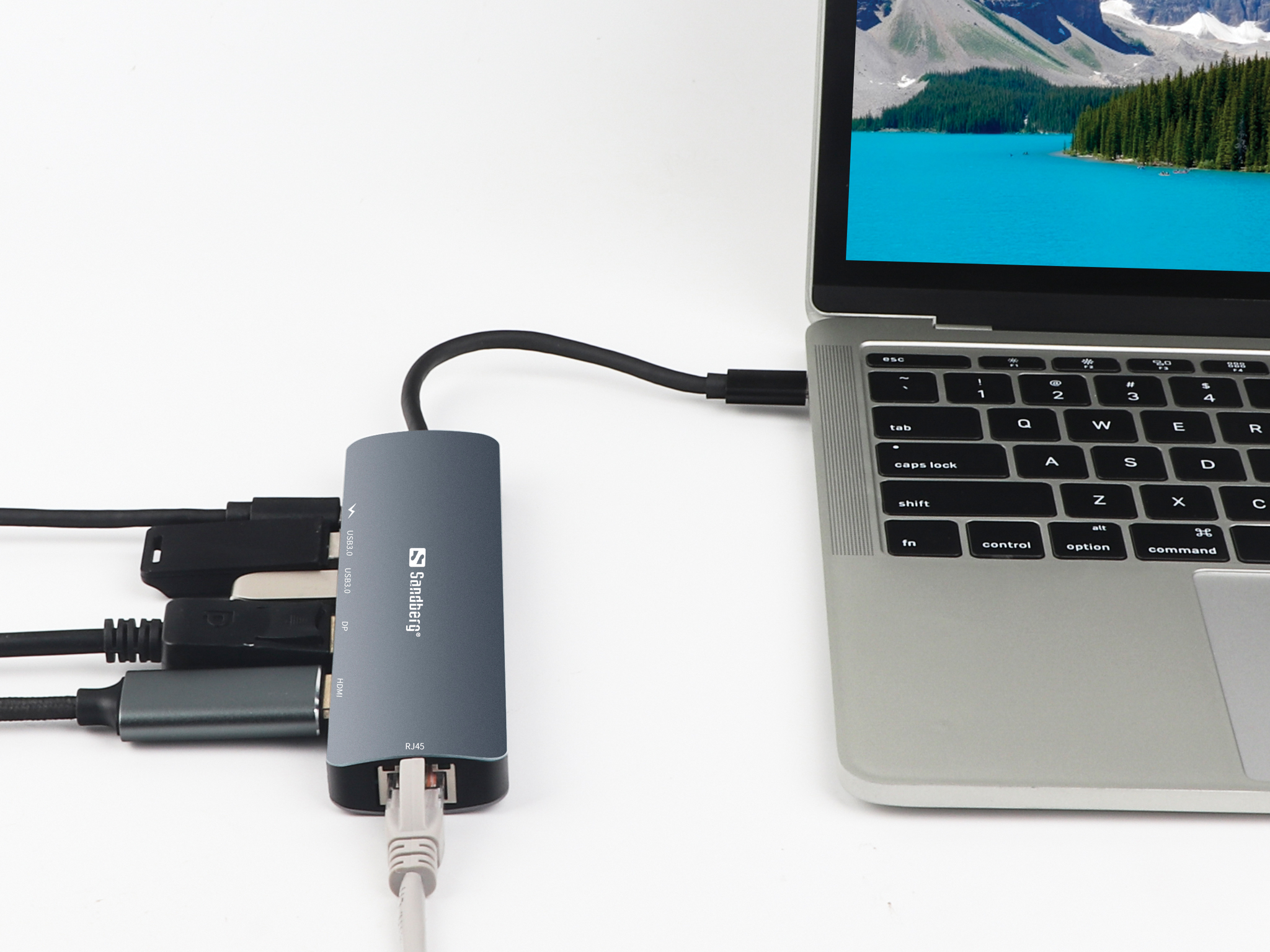 Laptop mit grauem Multiport-Adapter verbunden. Weißer Hintergrund.