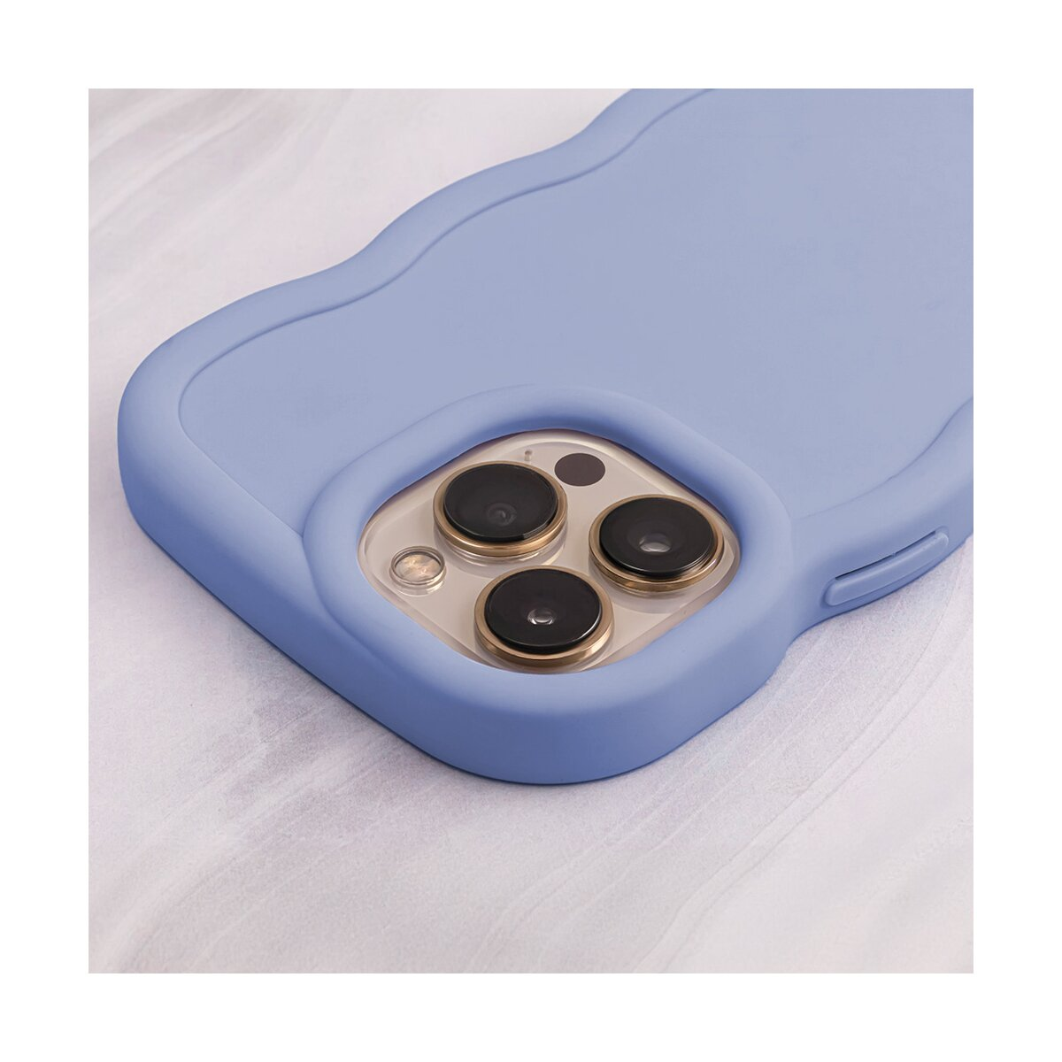 Primo piano di una custodia per telefono azzurra con bordo ondulato. Tre lenti della fotocamera sono visibili sul retro.