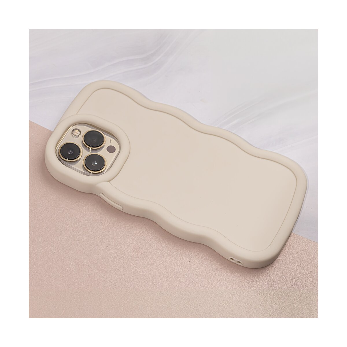 Custodia beige per telefono con bordi curvi e ritaglio per la fotocamera, su superficie rosa.