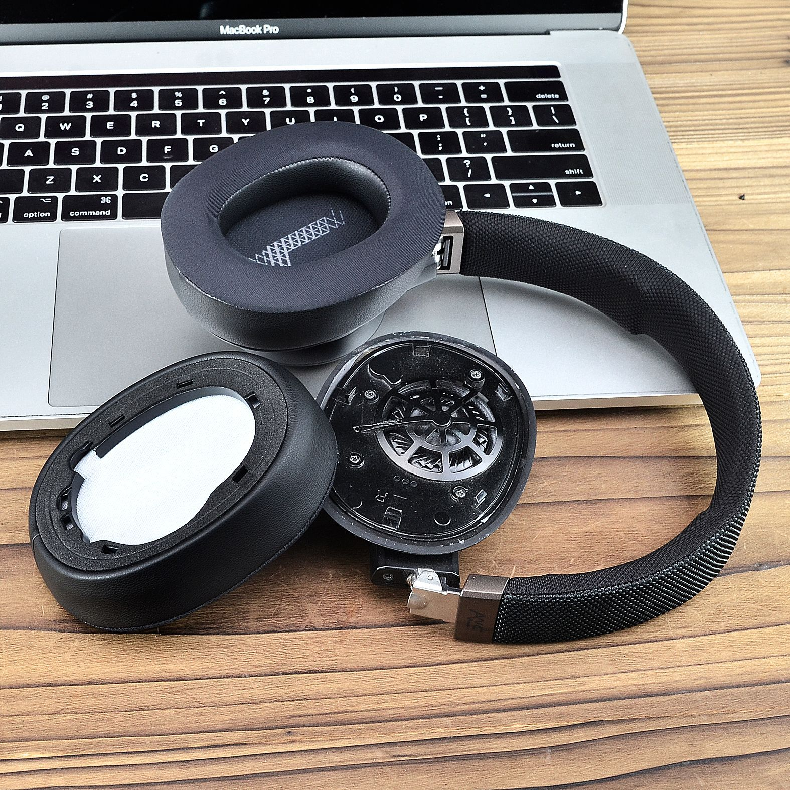 Kopfhörer, zerlegt, mit Ohrmuscheln, Polster und Kabel auf Laptop.