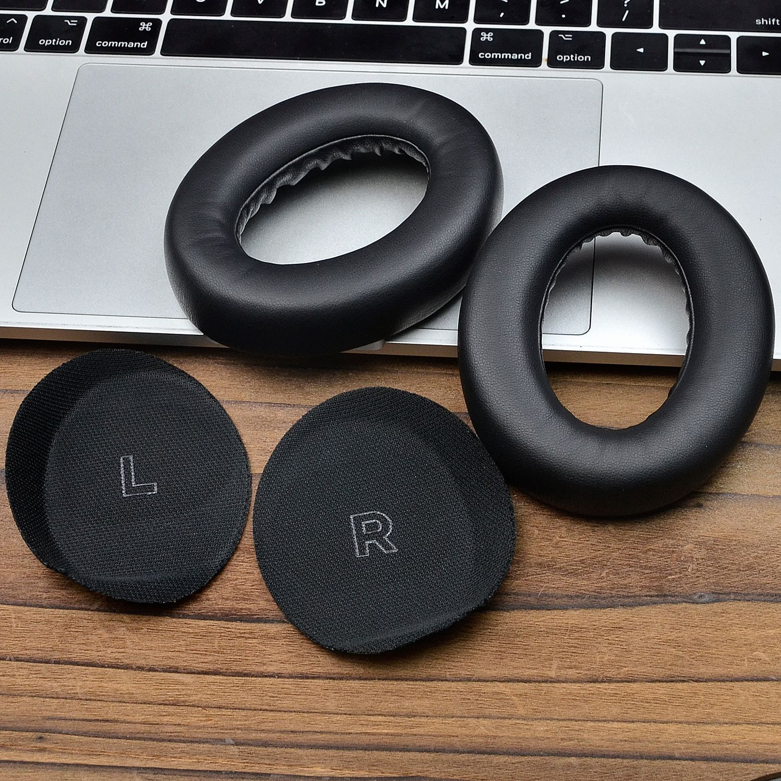 Poduszki nauszne i podkładki do słuchawek, oznaczone L i R, na klawiaturze laptopa.