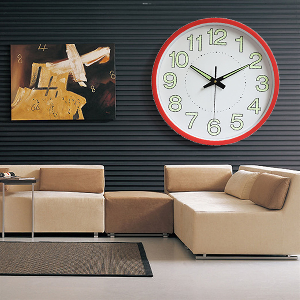 Eine rot umrandete Uhr an einer Wand, mit einem Gemälde und Möbeln in einem Raum.