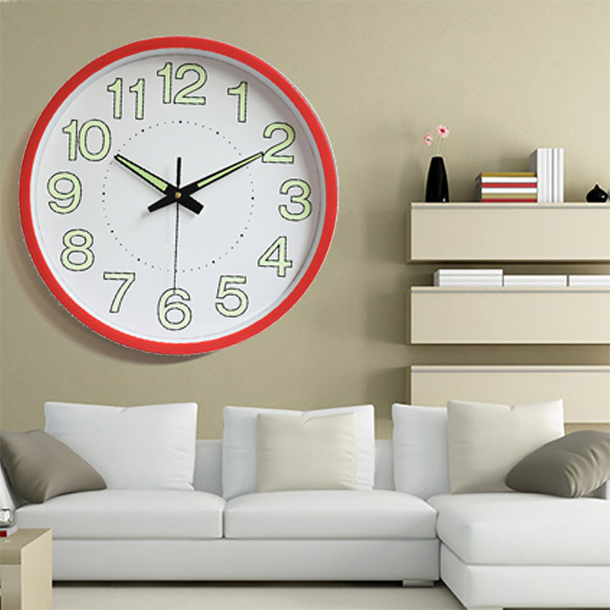 Eine runde Wanduhr mit rotem Rahmen, schwarzen Zeigern und großen, leuchtenden Zahlen.