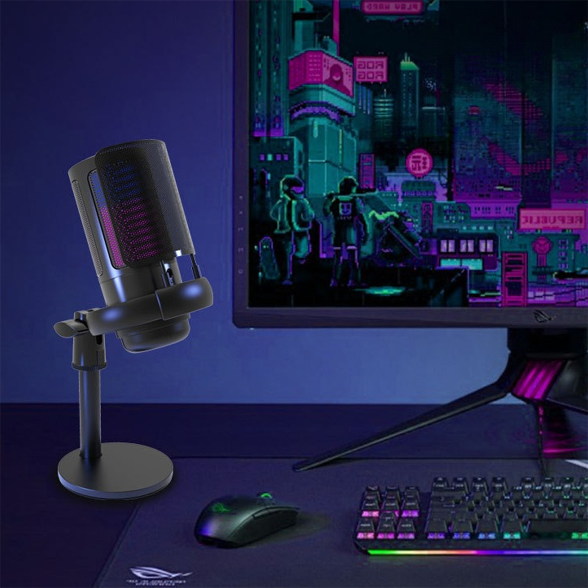 Ein schwarzes Mikrofon auf einem Ständer, eine Maus, eine Tastatur und ein Monitor mit Spielgrafik auf einem Schreibtisch.