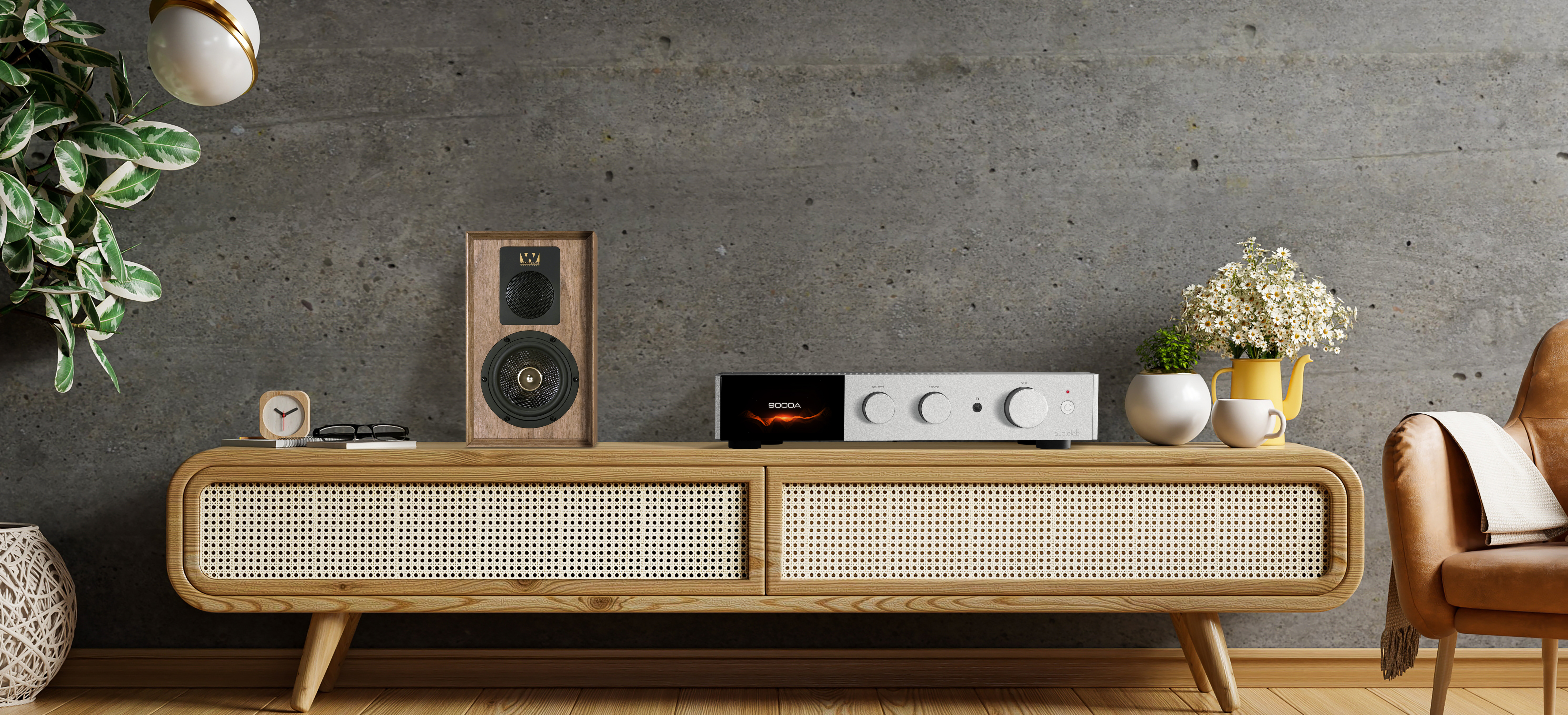 Holzschrank mit Audiogeräten. Ein Lautsprecher und eine Pflanze befinden sich links. Der Hintergrund ist Beton.