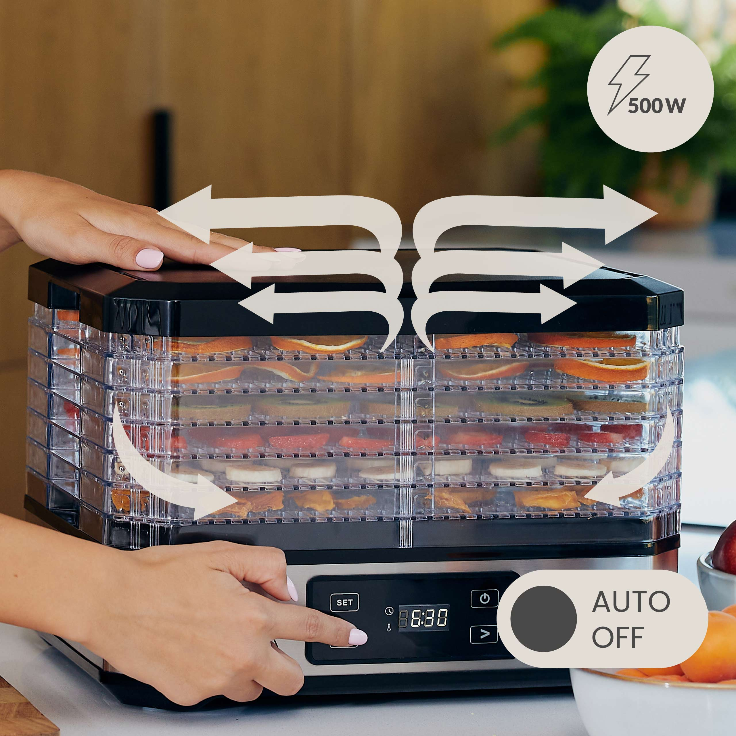 Dehydrator mit Lebensmittelschalen, Pfeilen und Bedienelementen. Eine Hand drückt eine Taste.
