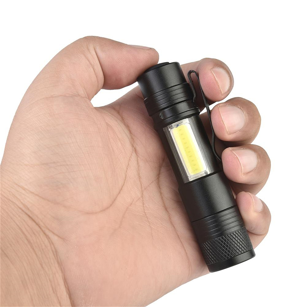 Hand hält eine schwarze Taschenlampe mit weißem COB-Licht. Sie hat einen Taschenclip.