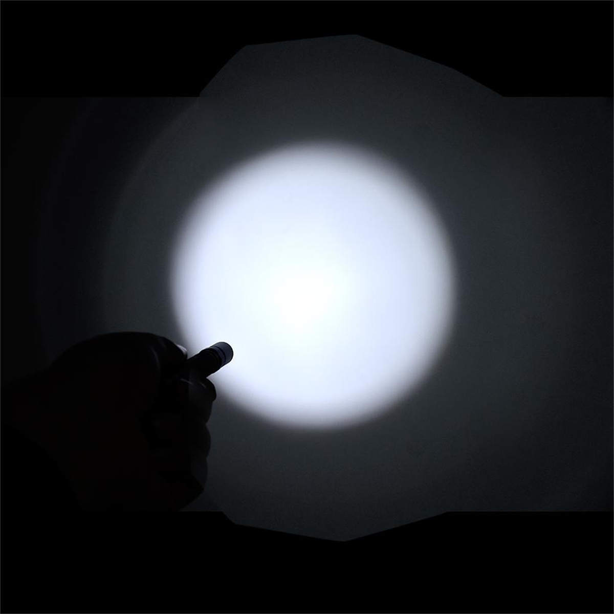 Hand, die eine Taschenlampe hält, die helles weißes Licht in der Dunkelheit scheint.