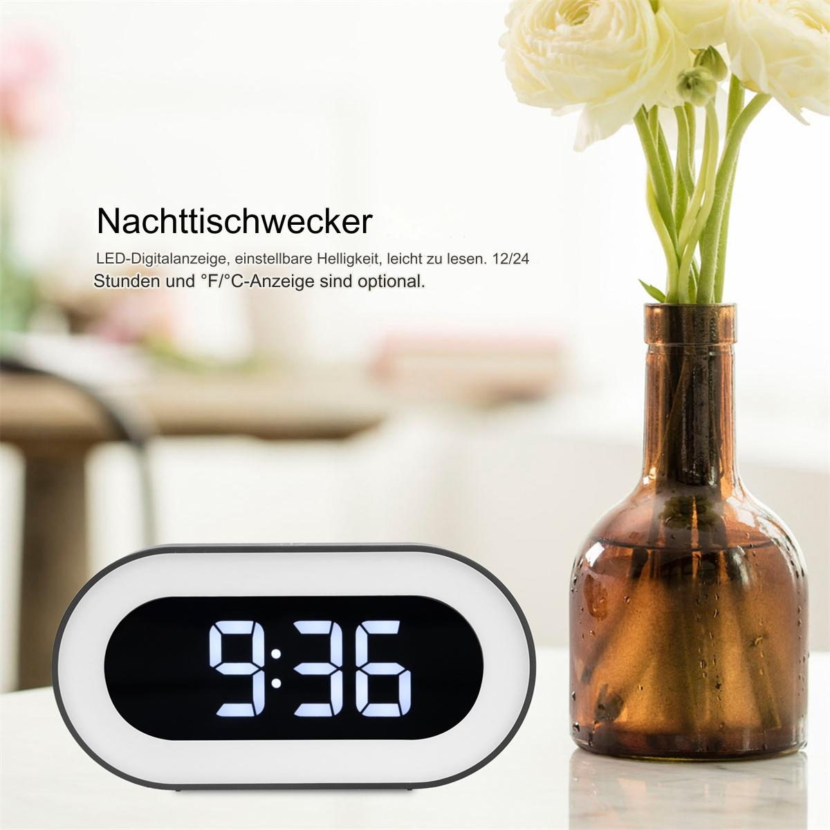 Digitaluhr zeigt 9:36. Rechts eine Vase mit Blumen.