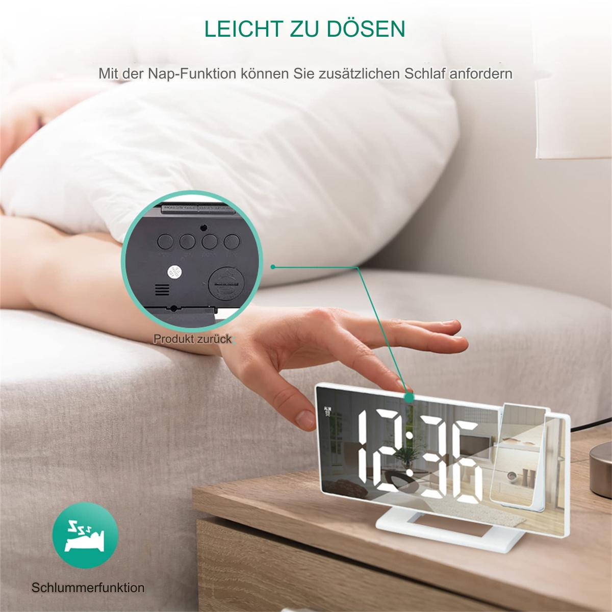 Ein digitaler Wecker mit weißem Display. Eine Hand greift nach der Uhr auf einem Nachttisch.