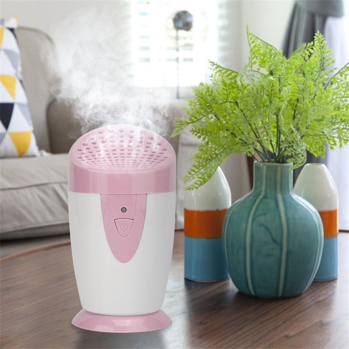 Rosa-weißer Aromadiffusor mit Dampf und einer Vase mit grünen Pflanzen.