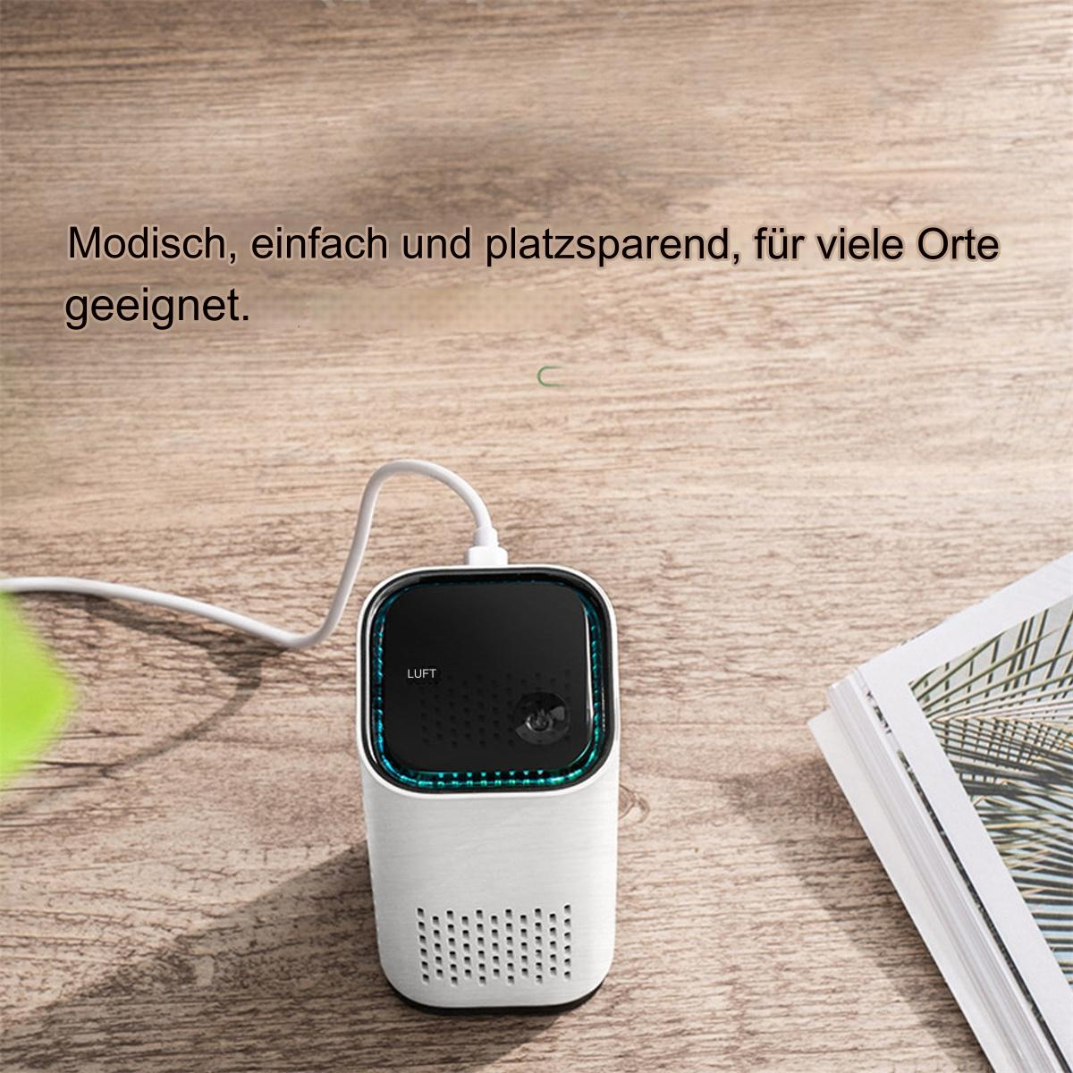 Ein weißer Luftreiniger mit schwarzem Oberteil, einem USB-Kabel und einem Buch auf Holzoberfläche.
