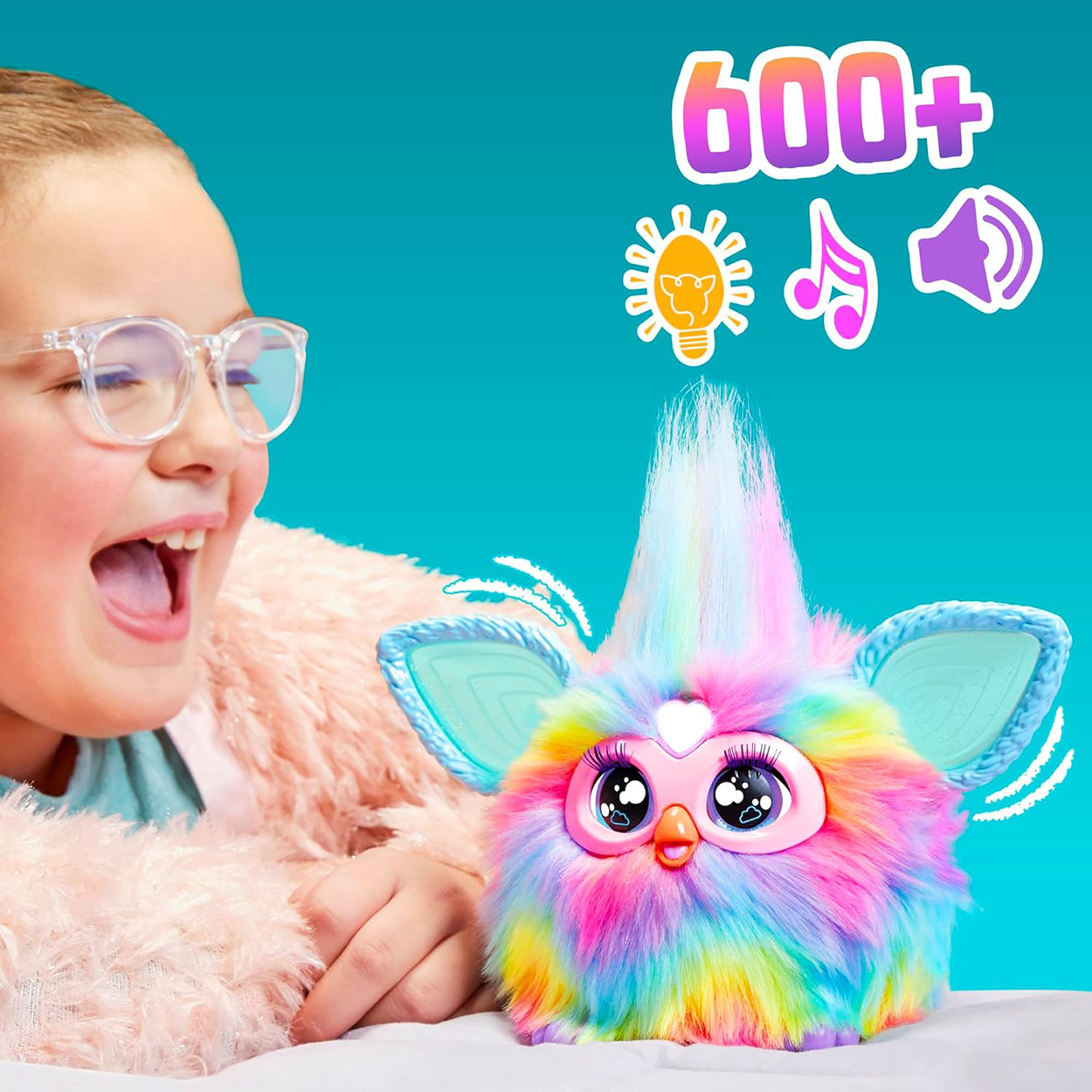 Ein Mädchen mit Brille freut sich über ein buntes Furby-Spielzeug.
